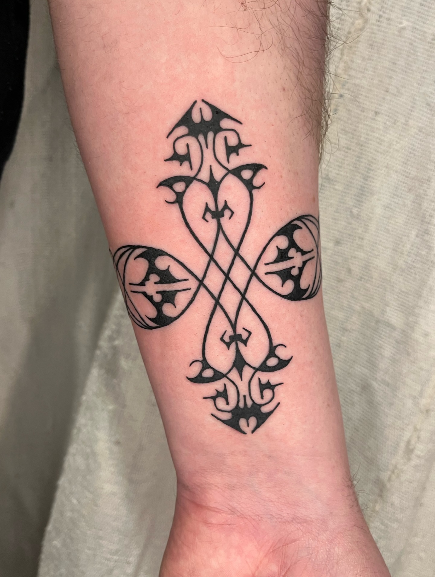 Cross black and grey tattoo on the forearm by Maris Hare, Philadelphia, Pennsylvania