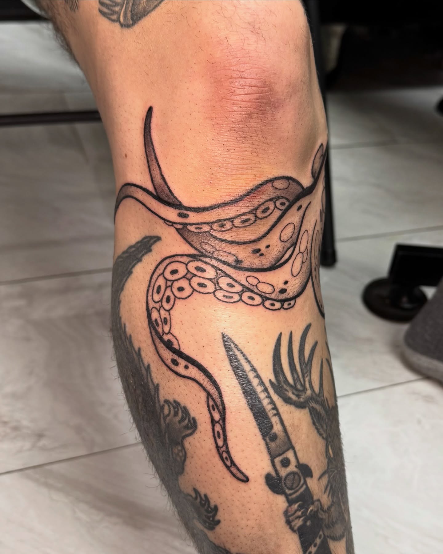 Octopus and knife black and grey tattoo on the forearm by Eden Allen