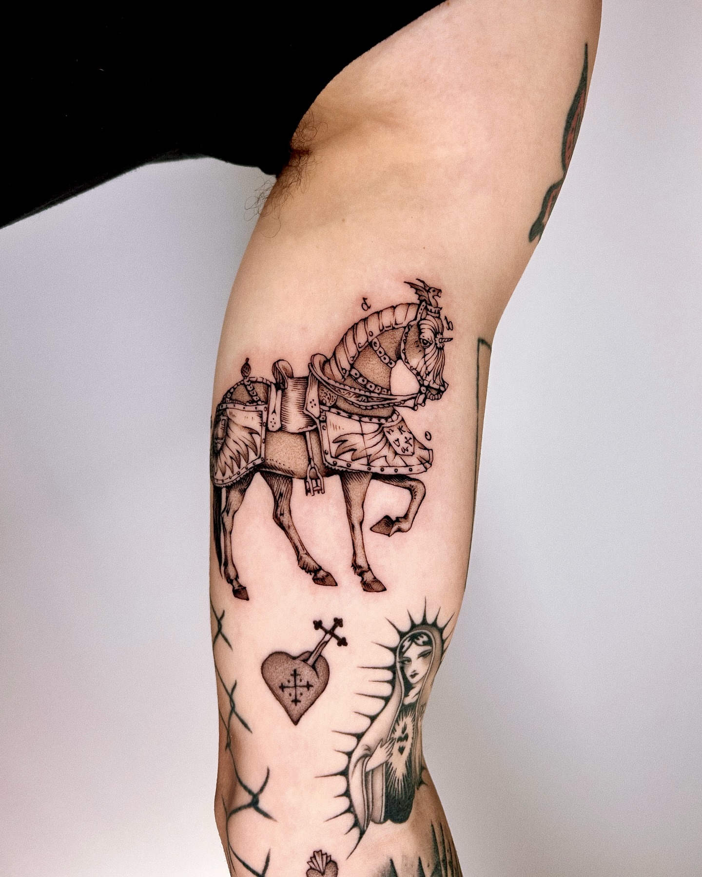 Horse and rider black and grey tattoo on the forearm by Montana Chambers