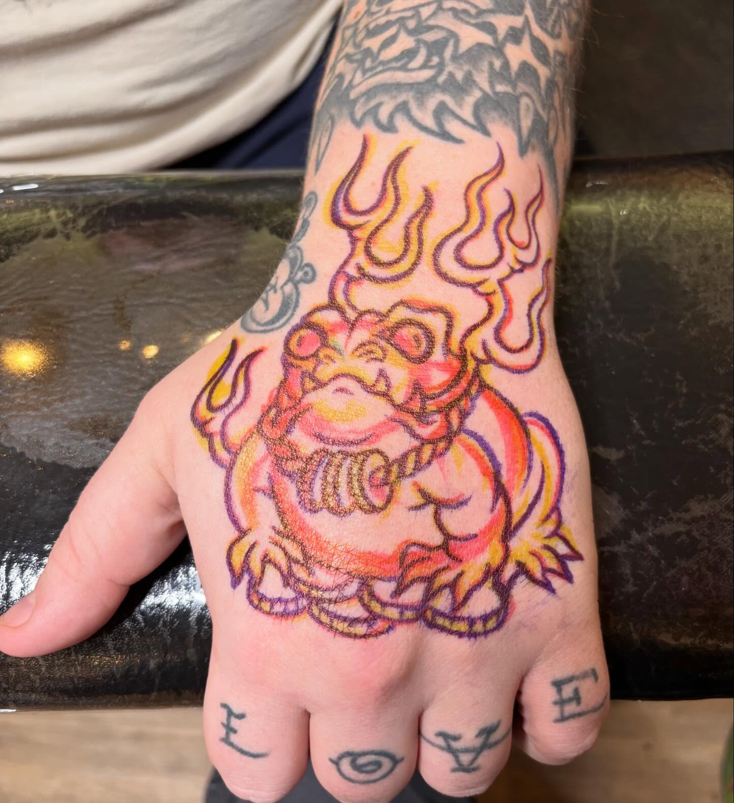 Lion with flames American traditional tattoo on the hand by Steve Reid