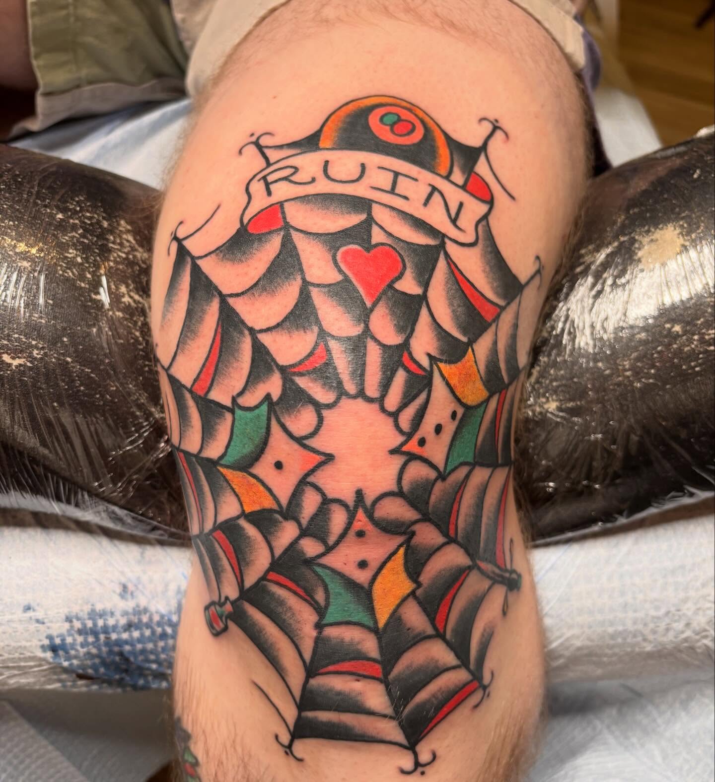 Spiderweb American traditional tattoo on the thigh by Steve Reid
