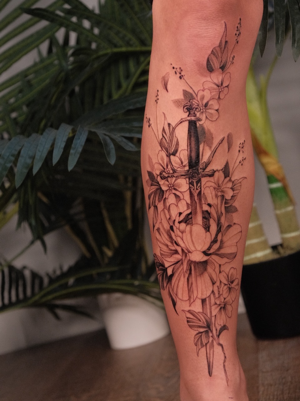 Floral arrangement with dagger black and grey tattoo on the forearm by JoeyJazz