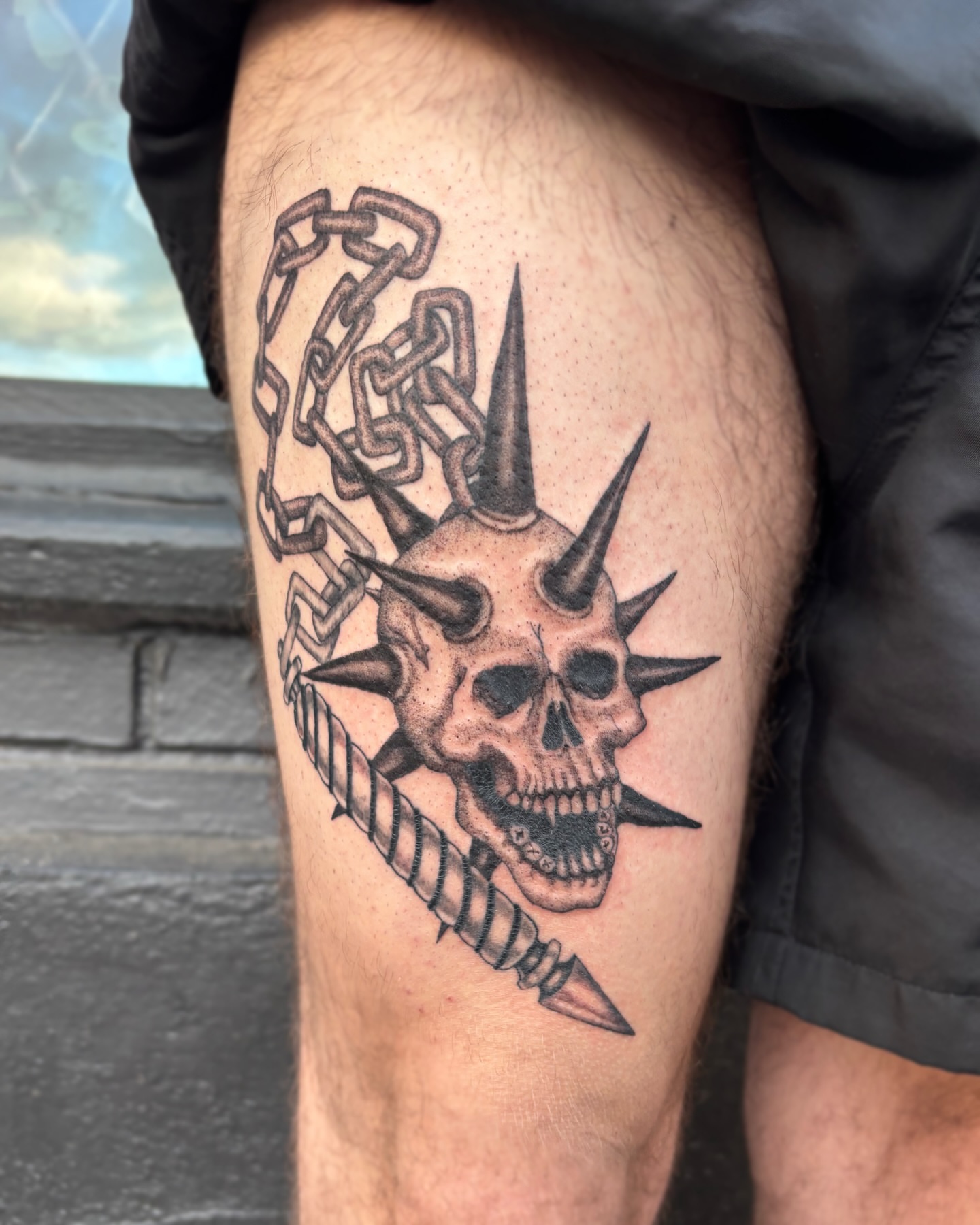 Spiked skull with chain realism tattoo on the thigh by Cooper, Portland, Oregon