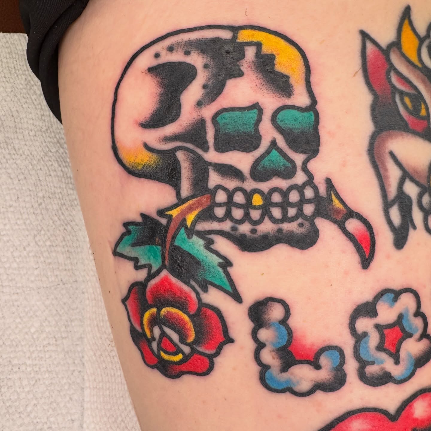 Skull and rose American traditional tattoo on the thigh by Kenny Kastro
