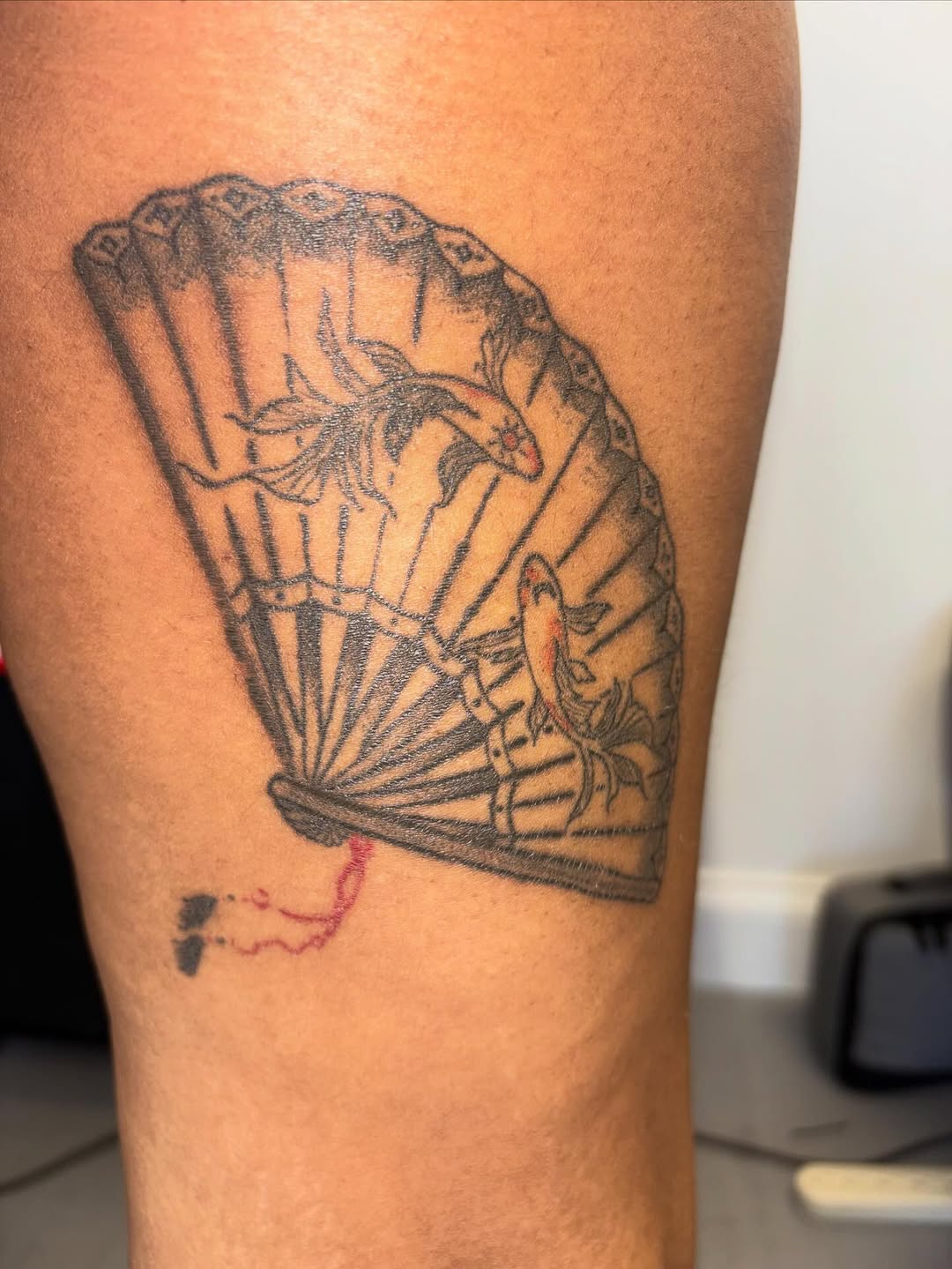 Fan with koi fish fine line tattoo on the forearm by Lopez Dautruche