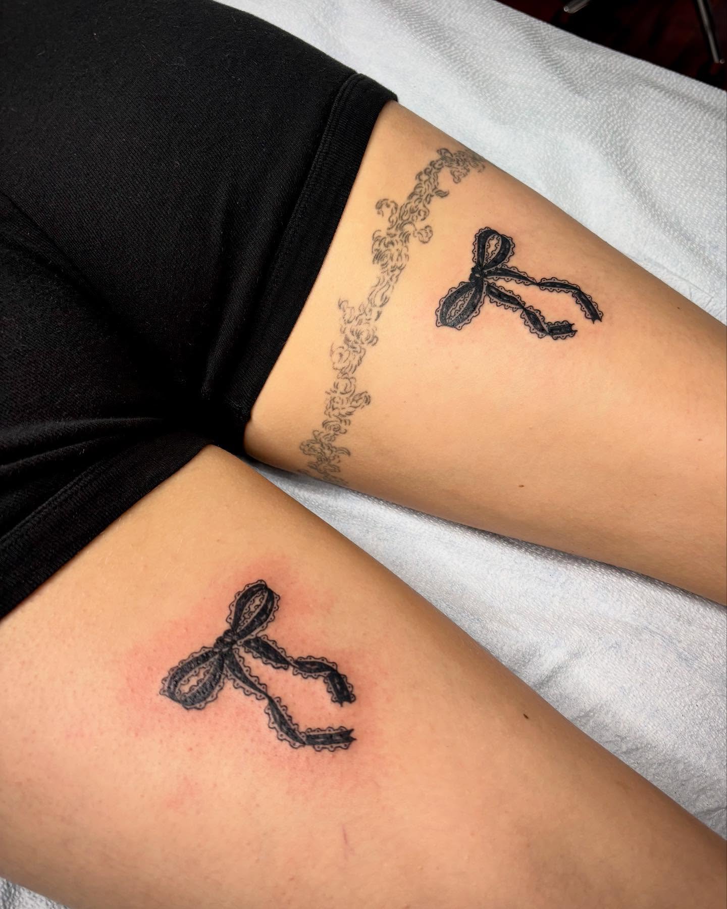 Lace bow black and grey tattoo on the thigh by kendle