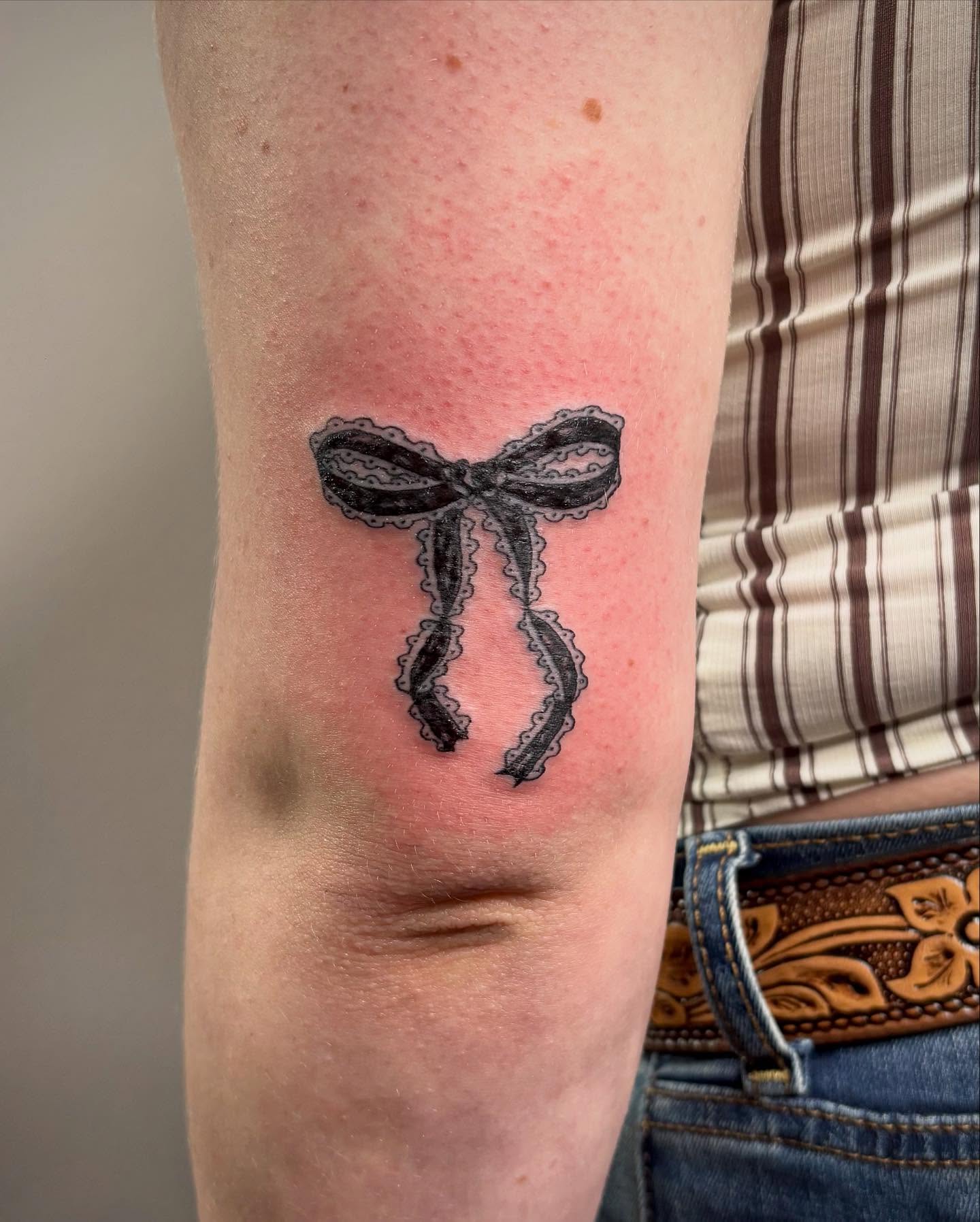 Bow black and grey tattoo on the forearm by kendle