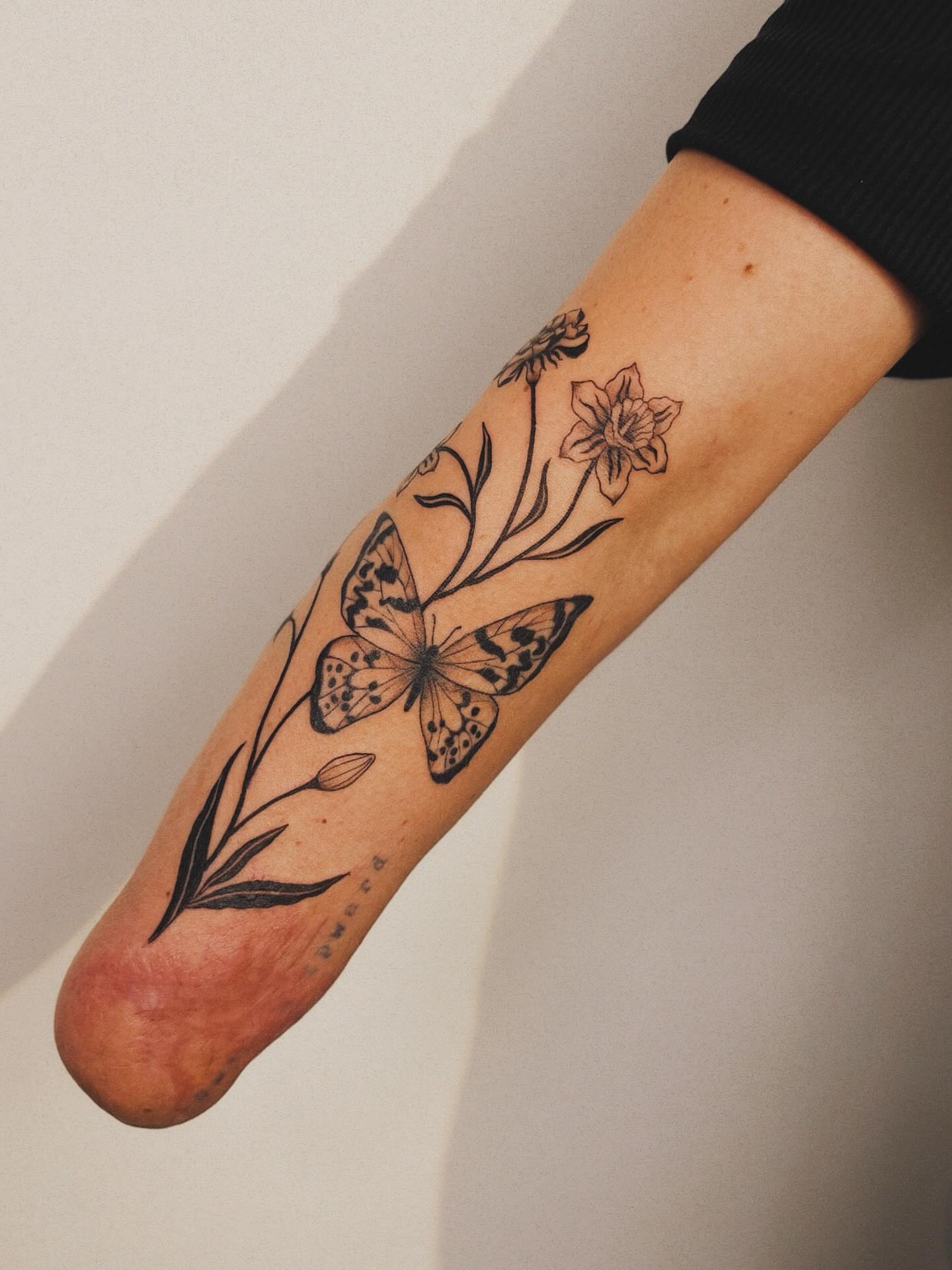 Butterfly and flowers black and grey tattoo on the forearm by b i l l i e, Seattle, Washington
