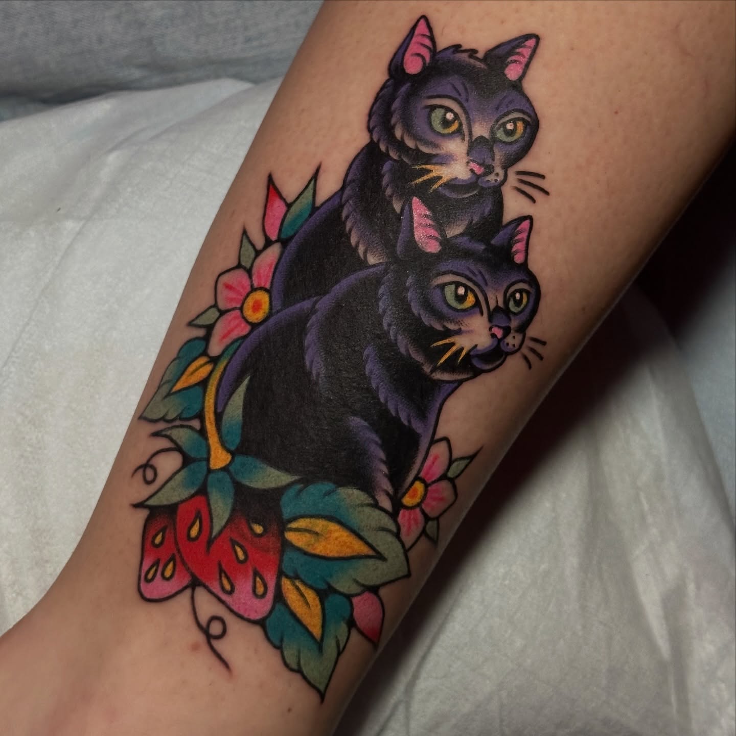 Two cats American traditional tattoo on the forearm by kira