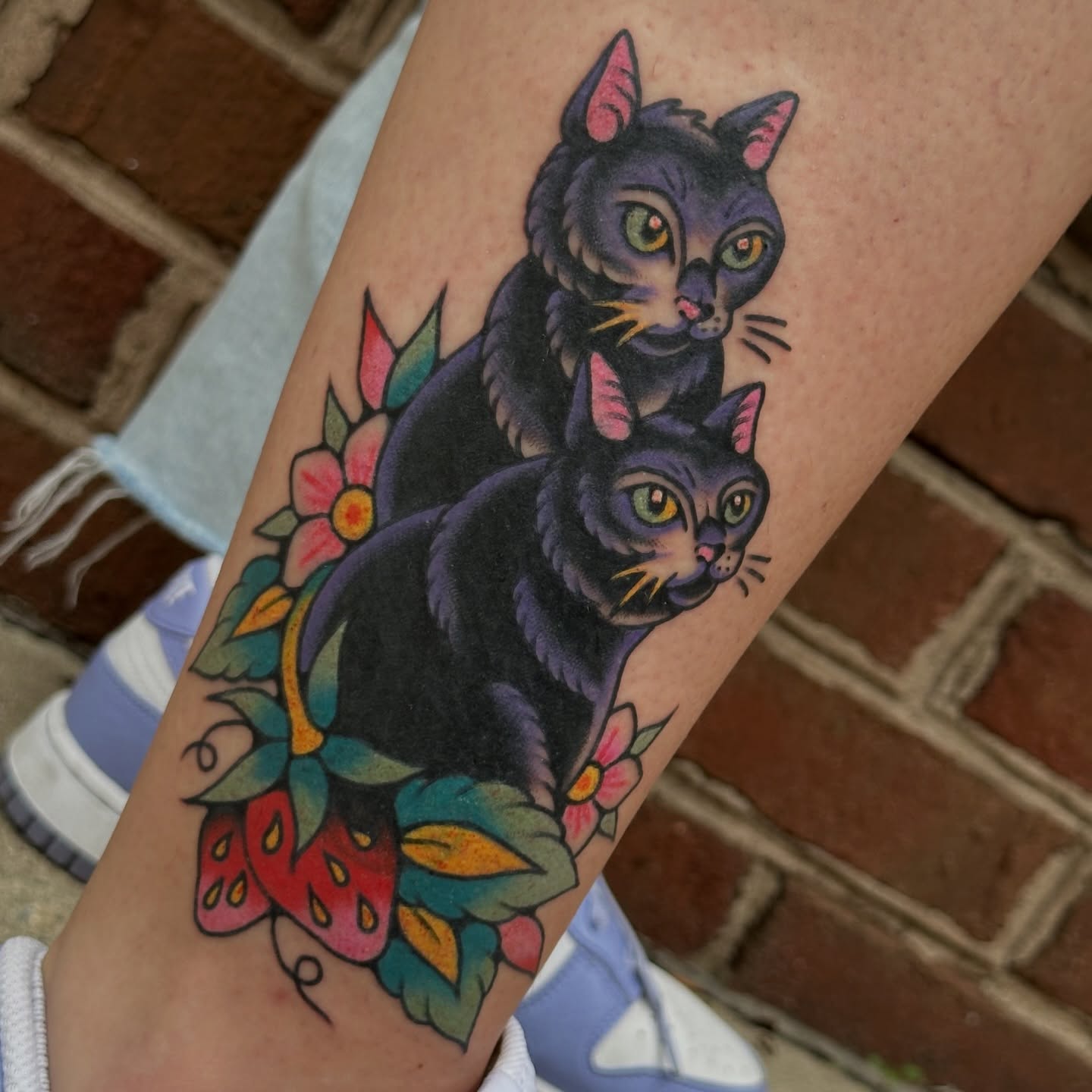 Two cats American traditional tattoo on the forearm by kira
