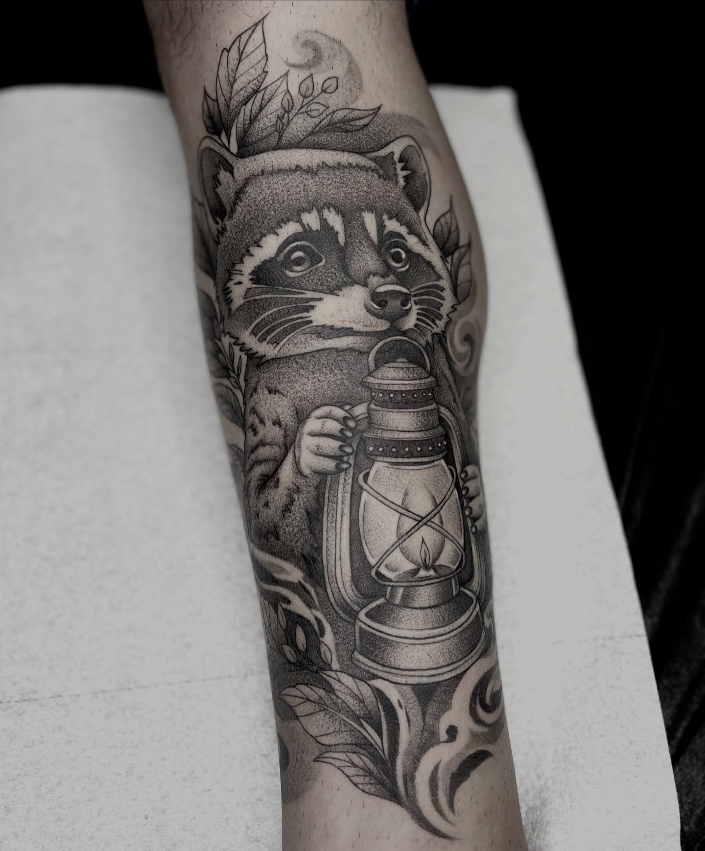 Raccoon holding lantern dotwork tattoo on the forearm by Ducky