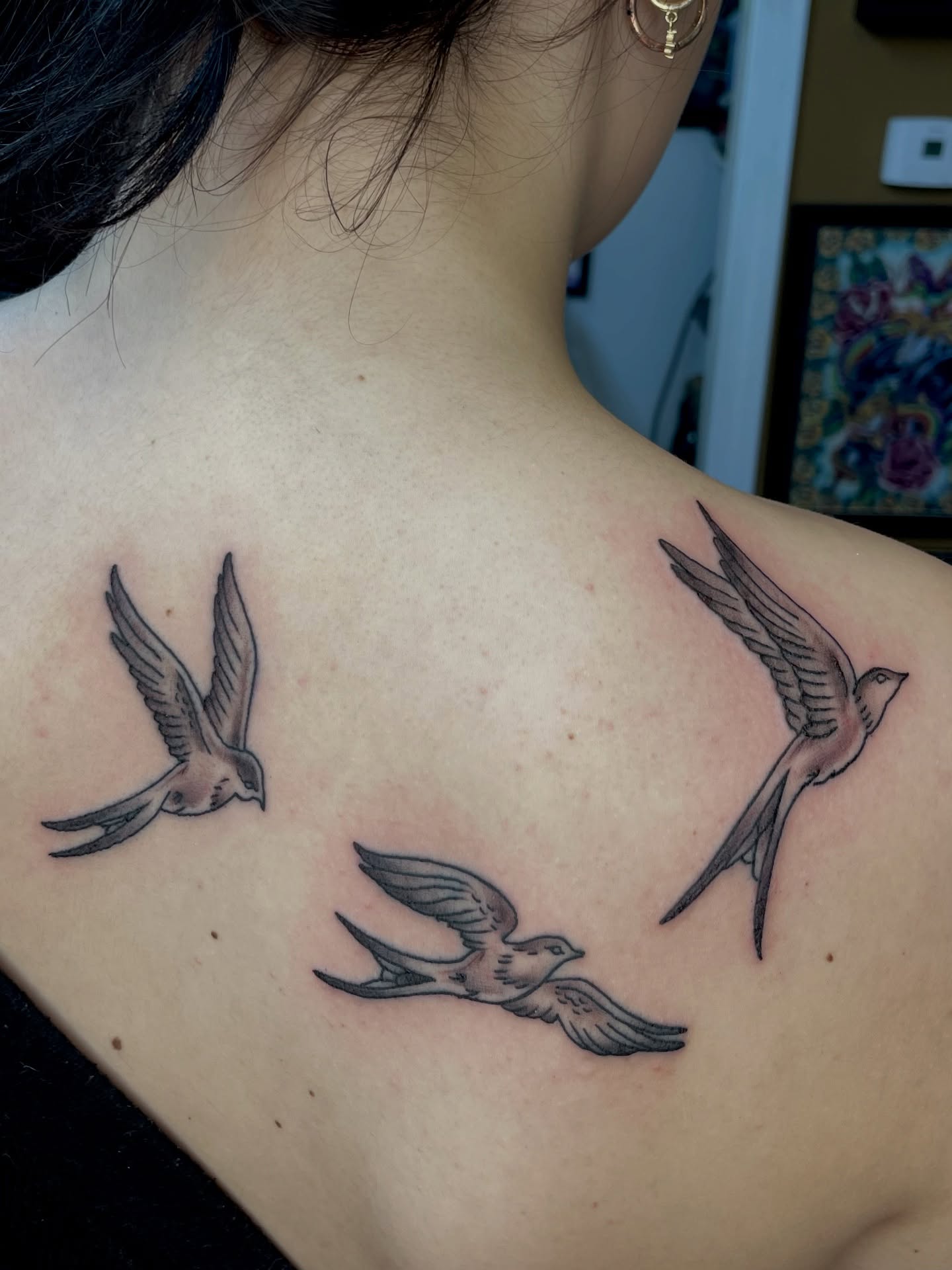 Swallows black and grey tattoo on the back by Strange Brew Tattoo