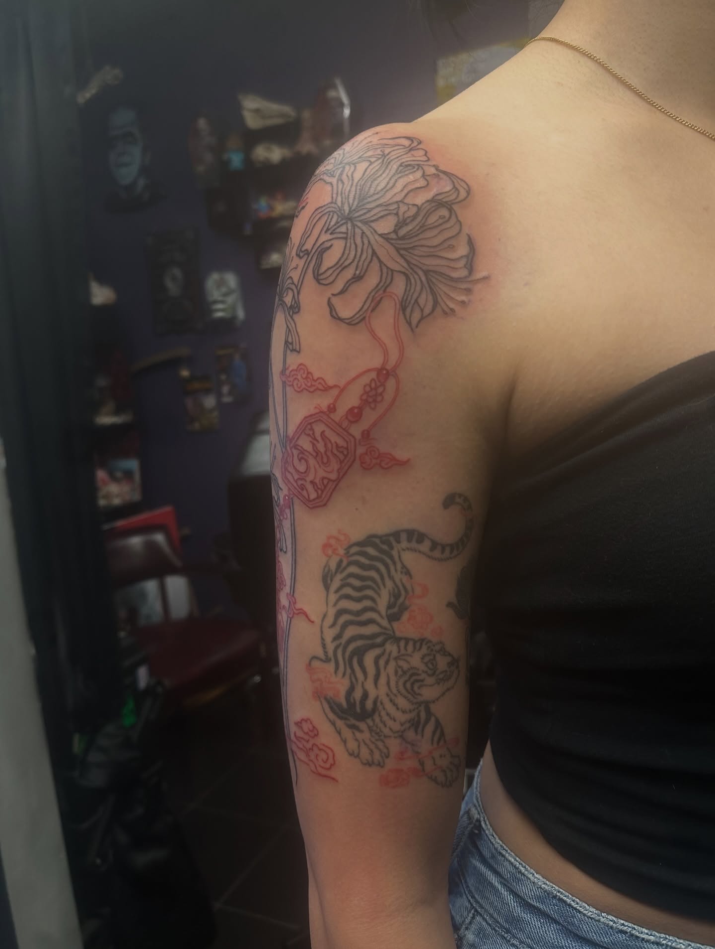 Tiger and chrysanthemum American traditional tattoo on the upper arm by Carly🪲 greensboro tattoo artist, Greensboro, North Carolina