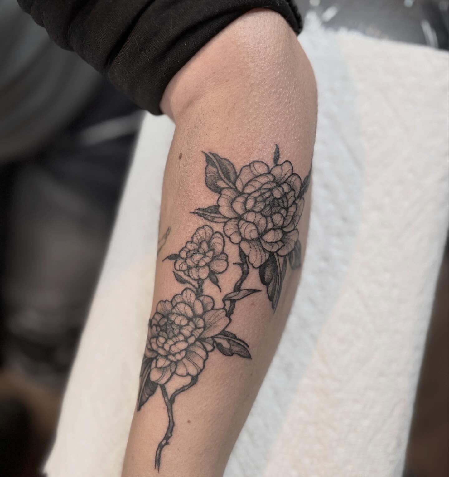 Peony flowers black and grey tattoo on the forearm by Dylan Coverdale