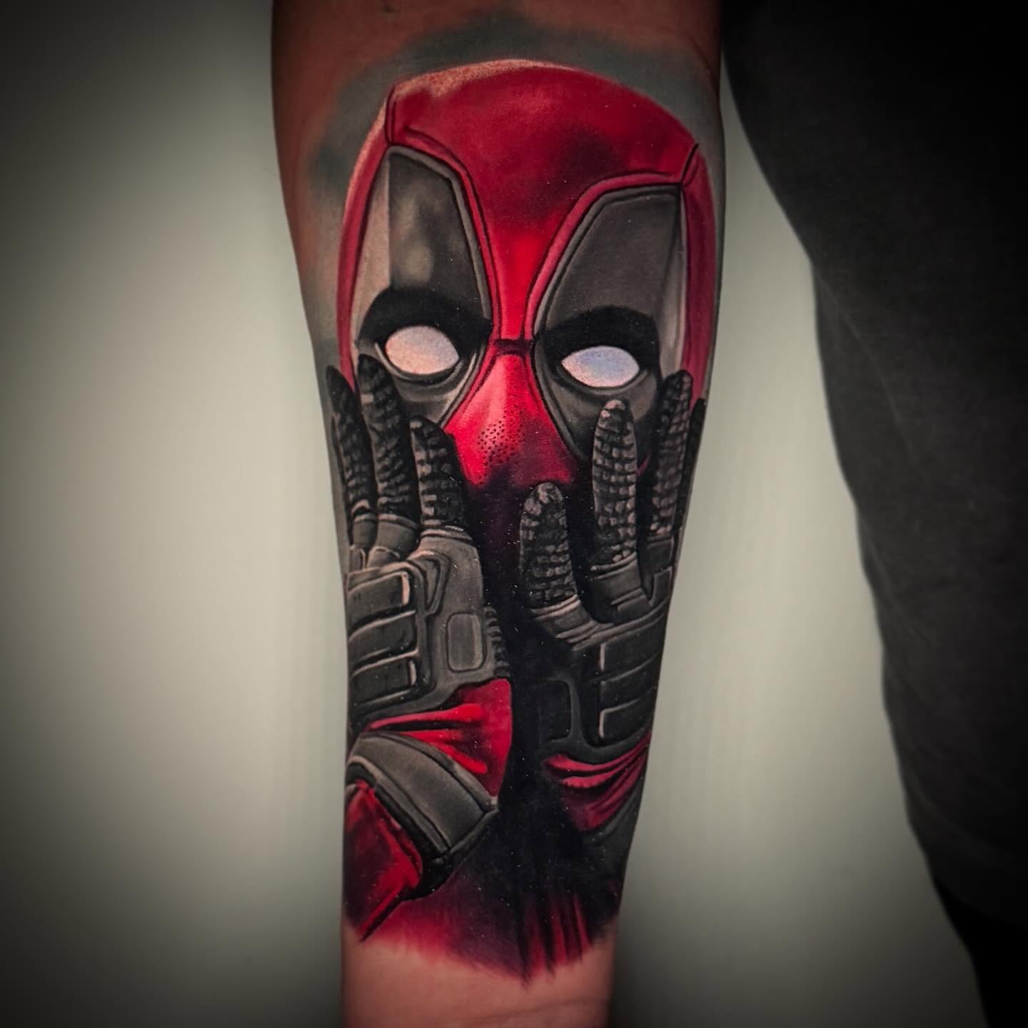 Deadpool mask realism tattoo on the forearm by TJ Schunemann