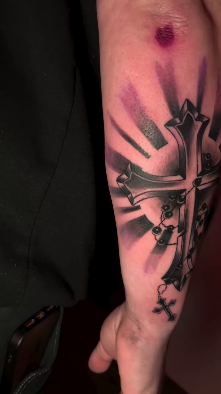Cross with hanging charms realism tattoo by Gage Cottrell