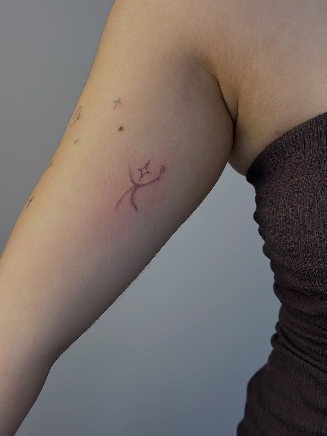 Figure reaching for star minimalist tattoo on the forearm by Cherry🥀