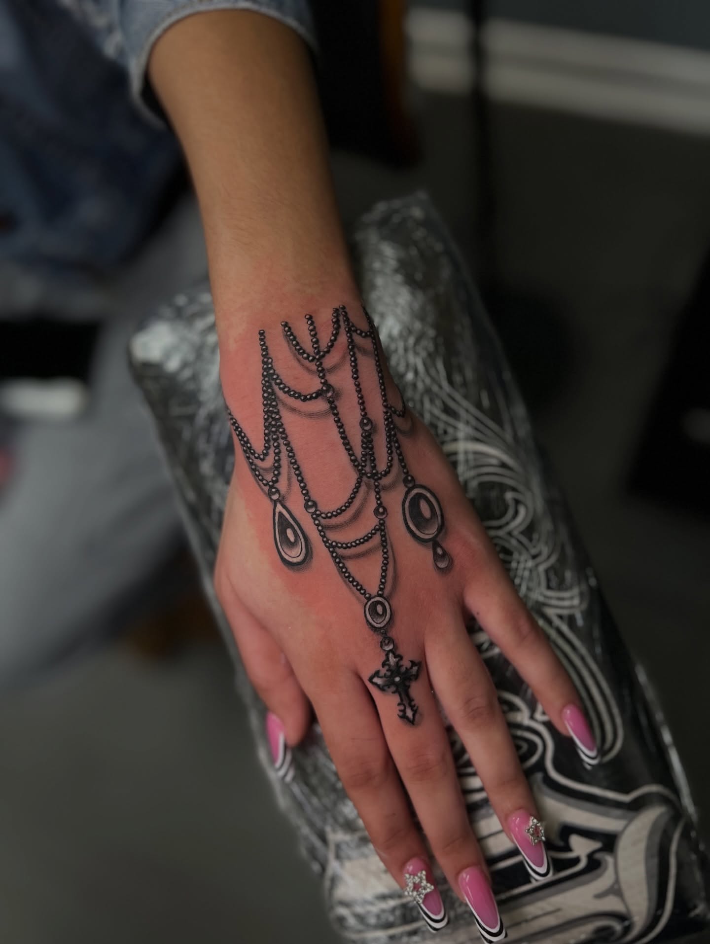Chain and cross black and grey tattoo on the hand by Vondrae