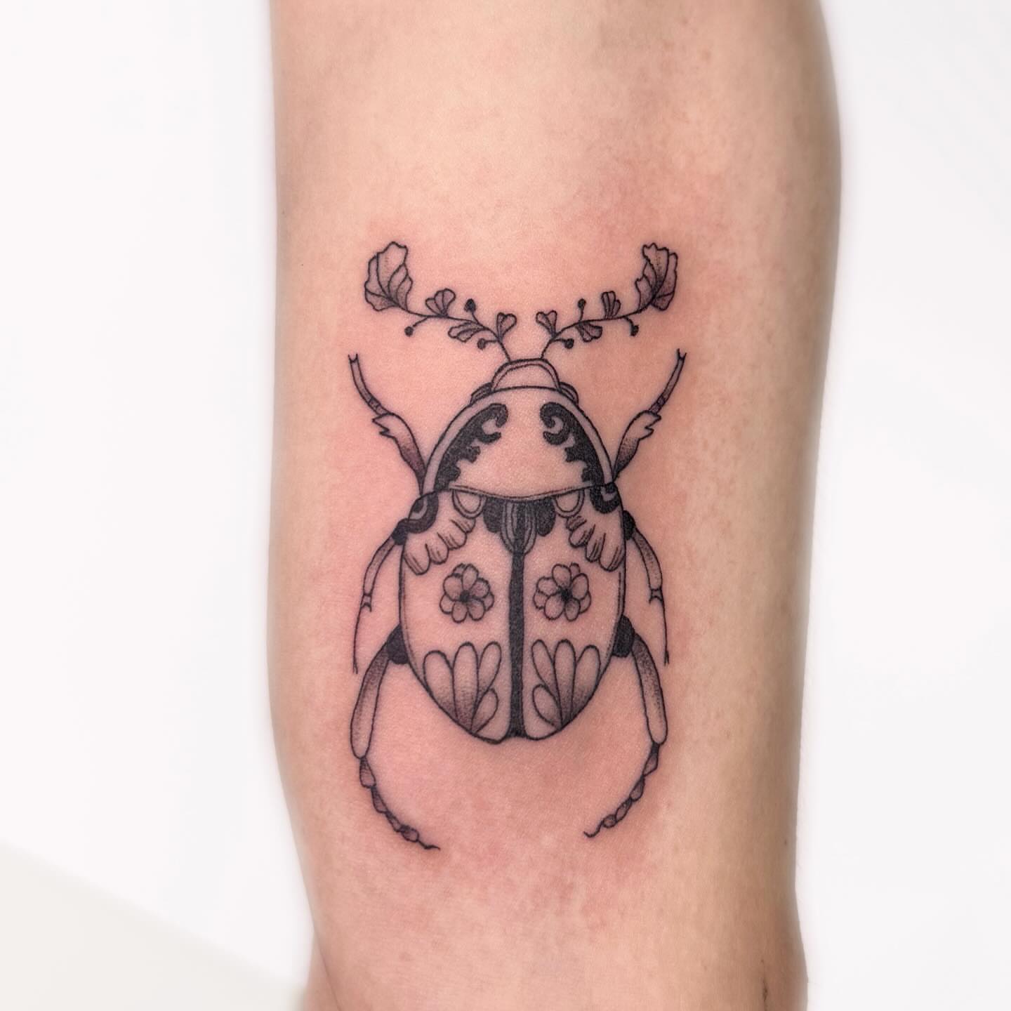 Beetle black and grey tattoo on the forearm by Nika