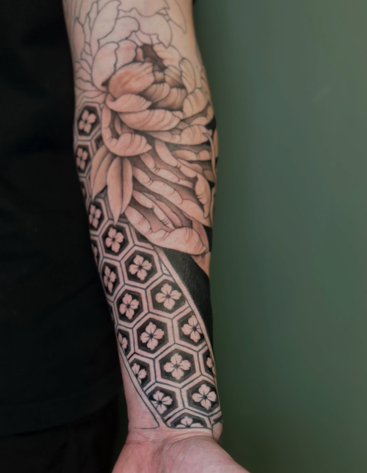 Peony and geometric pattern geometric tattoo on the forearm by Sarah Margaret