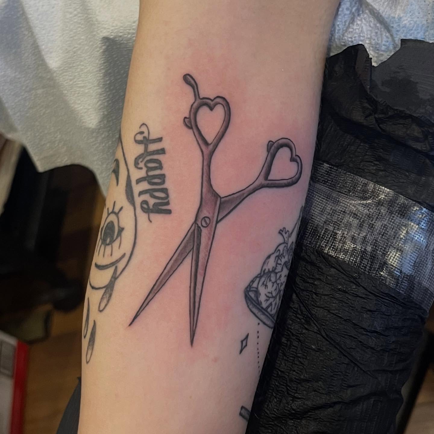 Scissors with heart handles black and grey tattoo on the forearm by Franky Sharpz