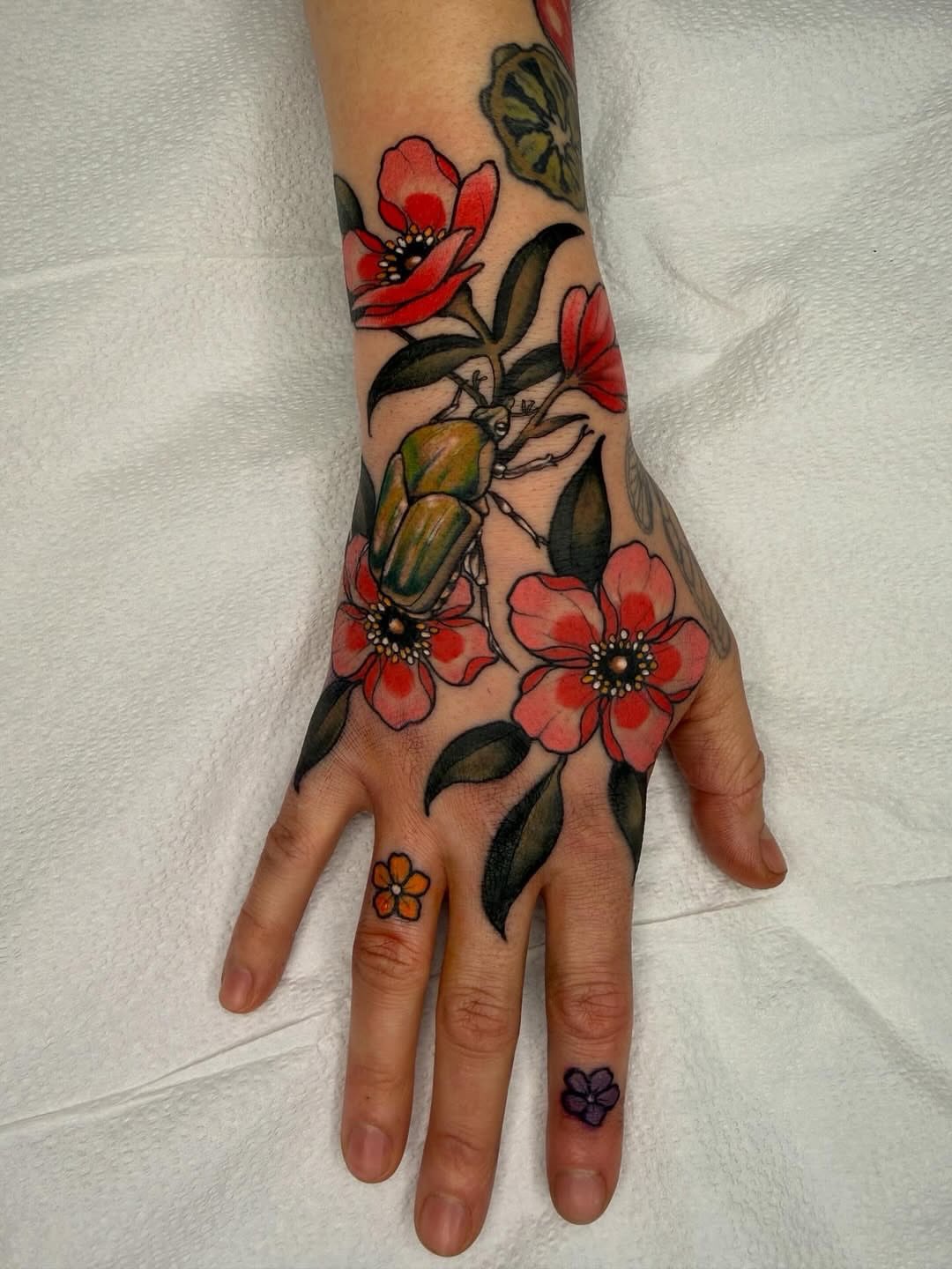 Flowers and beetle American traditional tattoo on the hand by Samantha Compasso Ford