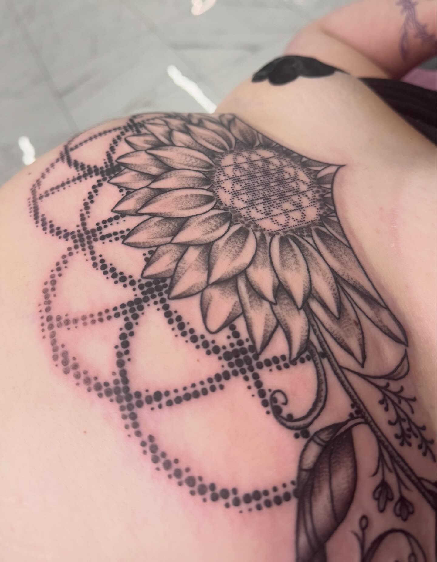Sunflower dotwork tattoo on the shoulder by Ember