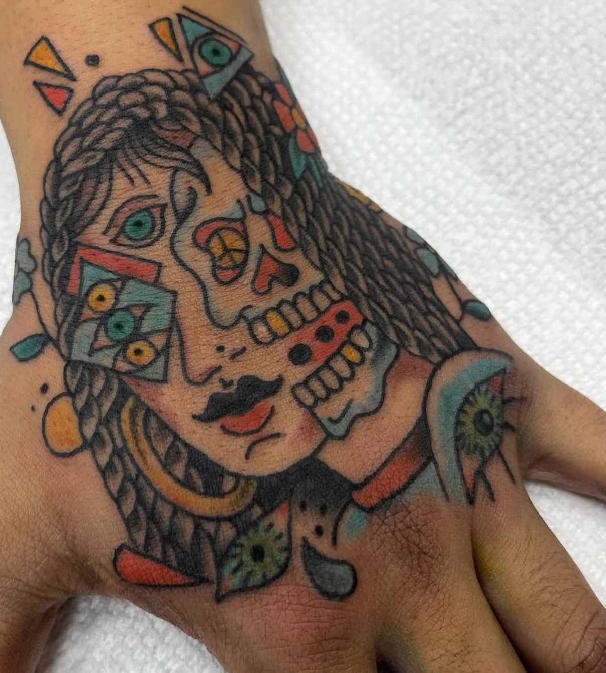 Day of the Dead skull American traditional tattoo on the hand by c☮︎urt