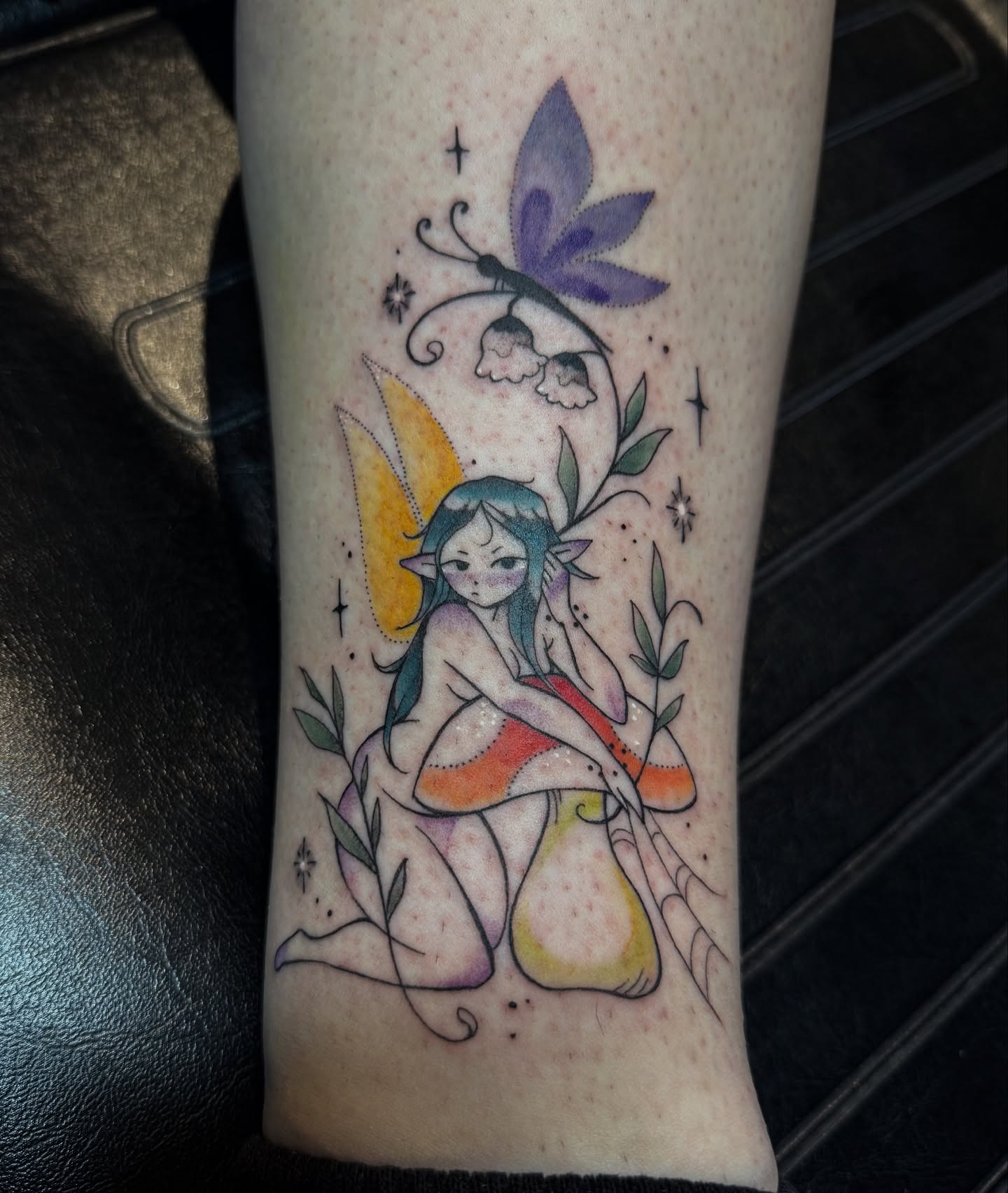 Fairy on mushroom watercolor tattoo on the forearm by Jynx