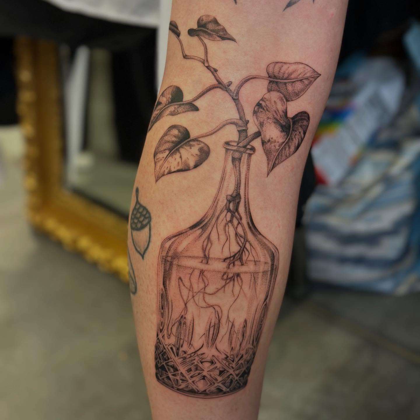 Plant in bottle black and grey tattoo on the forearm by sara scak, Lakewood, Ohio