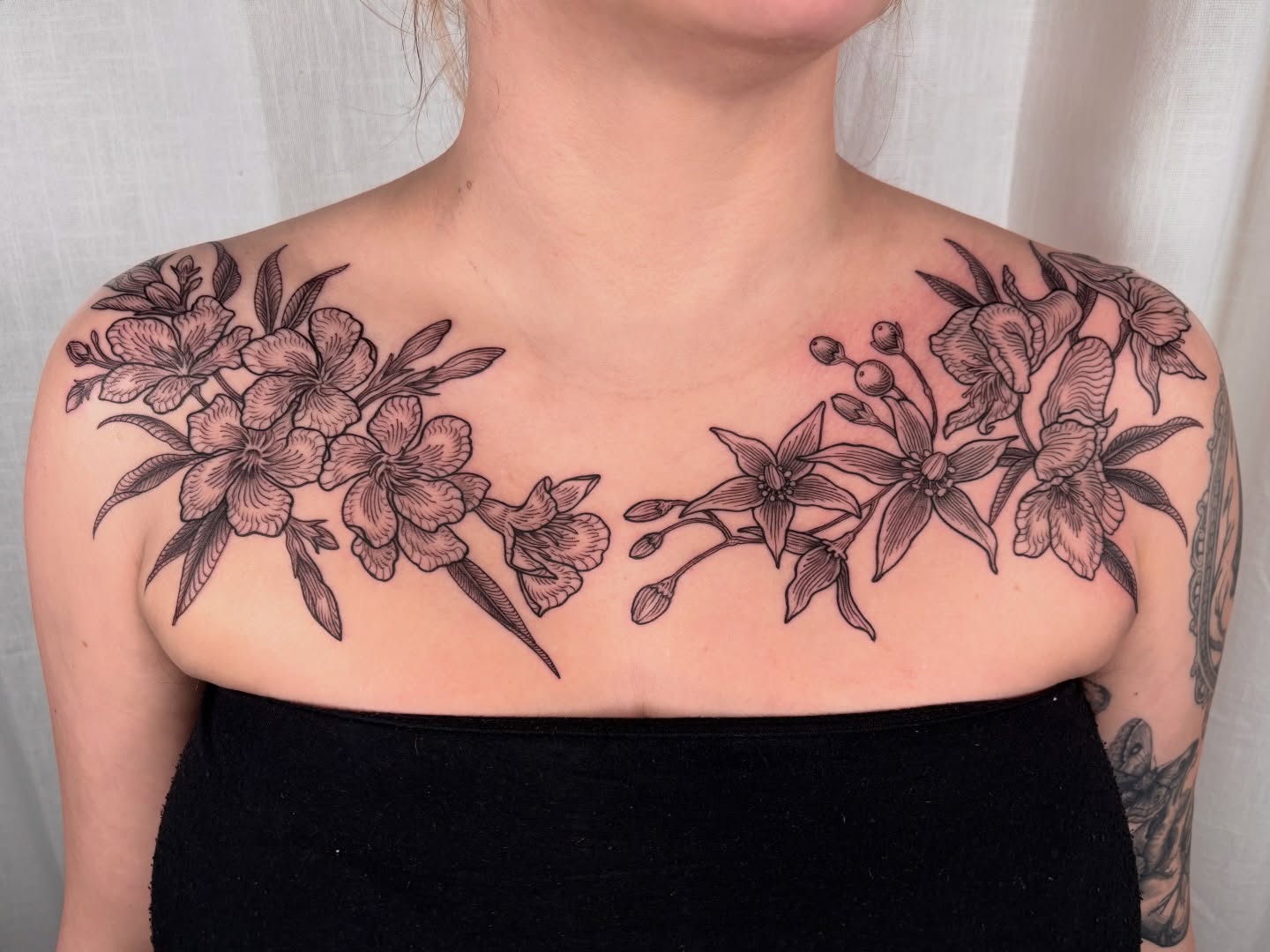 Floral arrangement black and grey tattoo on the chest by Maggie