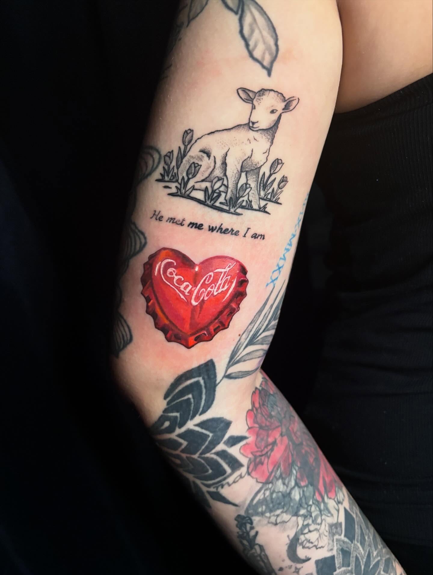 Heart with Coca-Cola logo black and grey tattoo on the forearm by Rayvin Patton