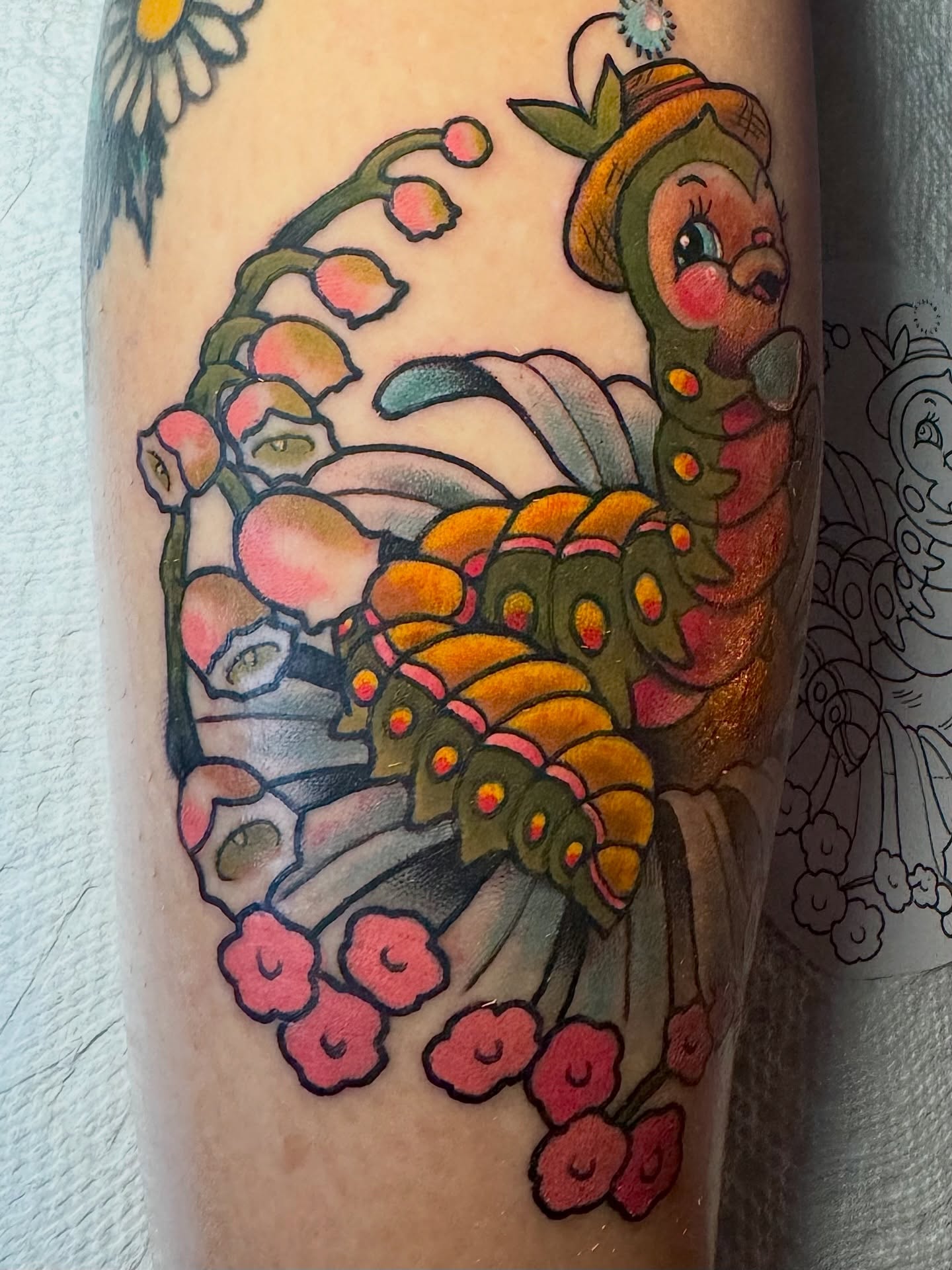 Caterpillar and flowers American traditional tattoo on the forearm by Stacey Martin Smith