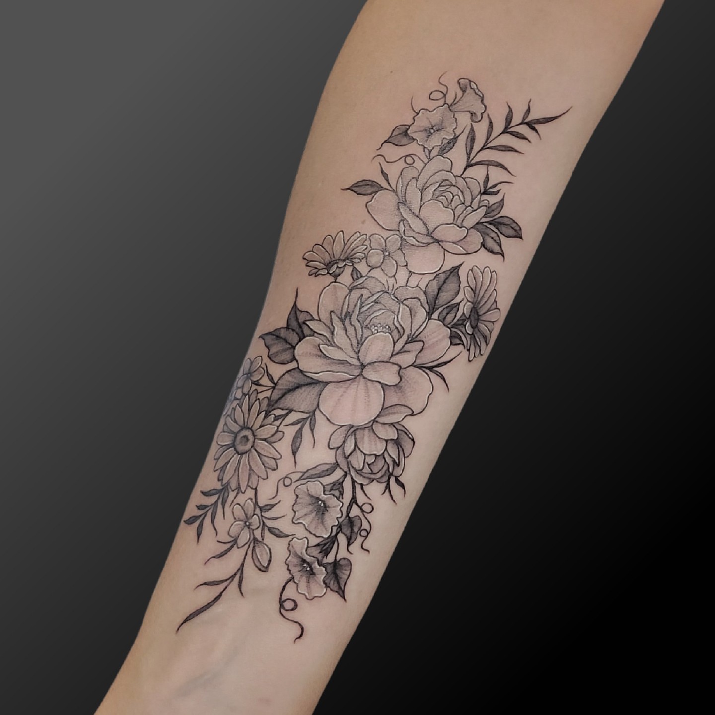 Floral bouquet black and grey tattoo on the forearm by Arick Reese