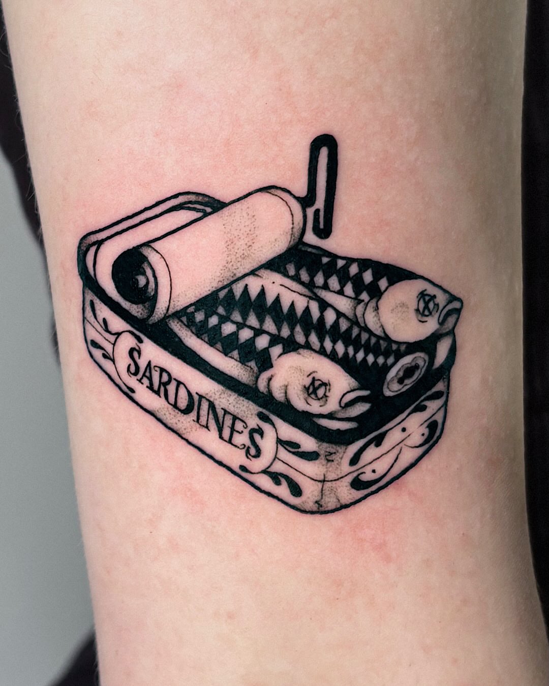 Sardine can black and grey tattoo on the forearm by Kal