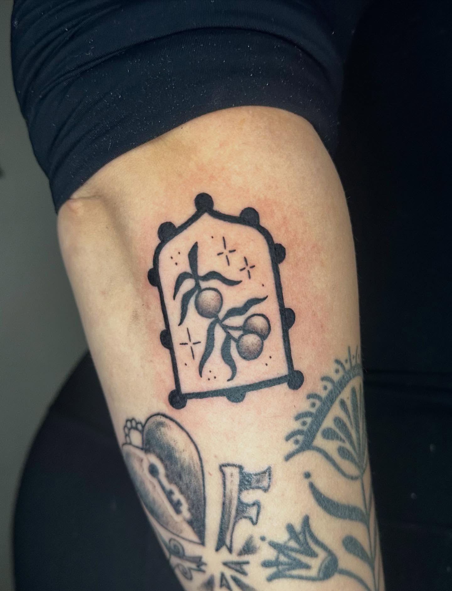 Fruit and leaves black and grey tattoo on the thigh by Jadelin, San Francisco, California