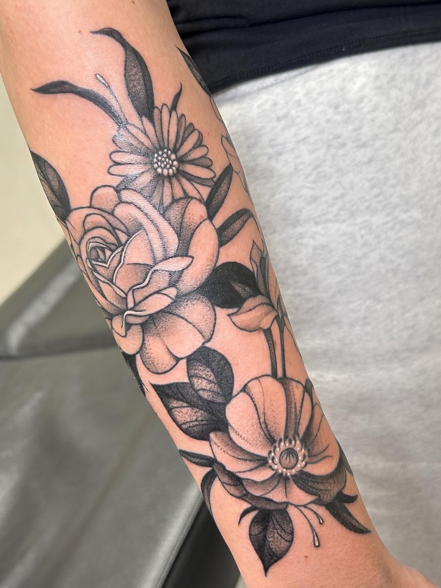 Floral arrangement black and grey tattoo on the forearm by kuna ink