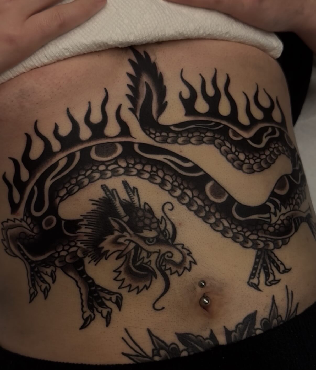 Dragon black and grey tattoo on the torso by Cory Allen