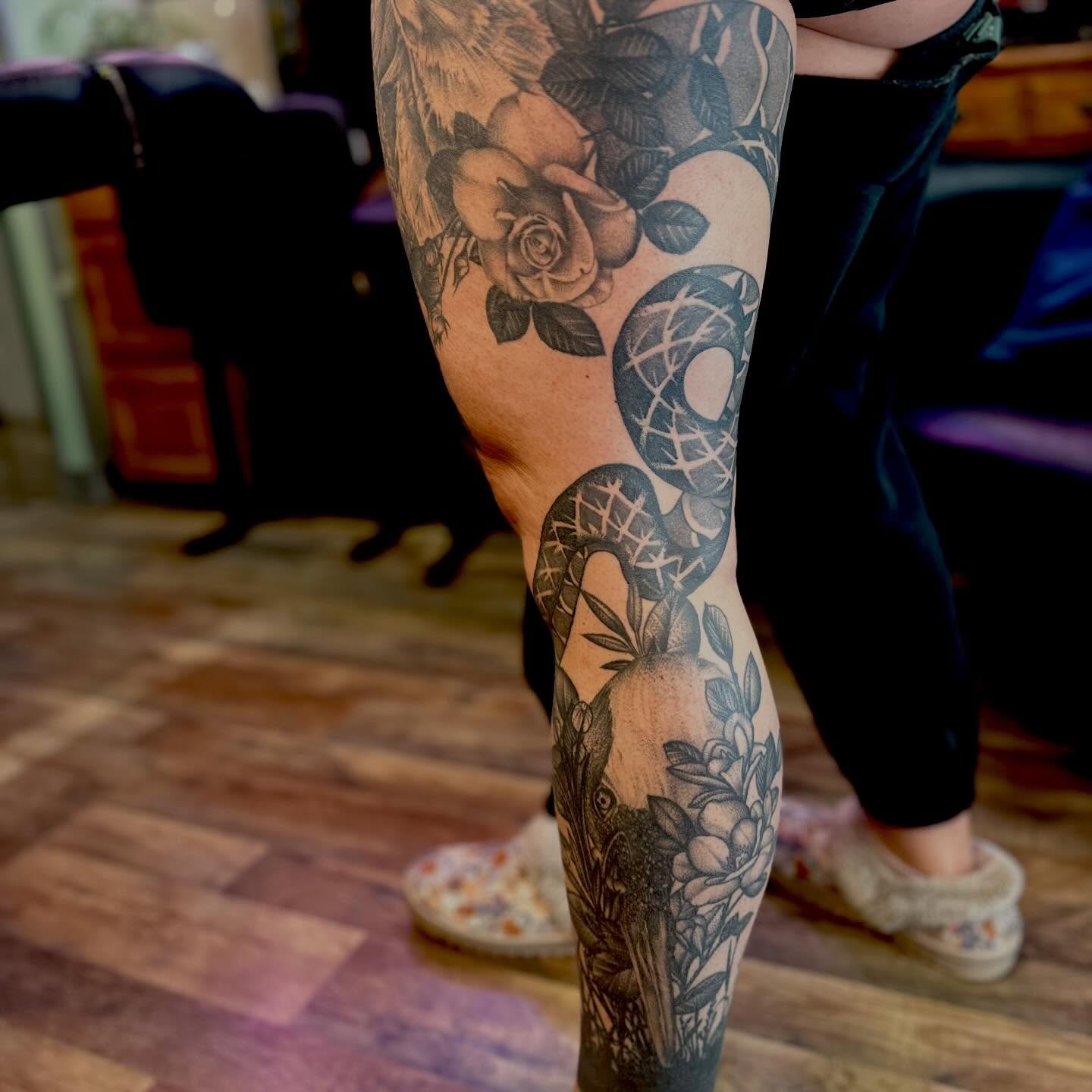 Snake and floral realism tattoo on the forearm by Leeuh Vandever