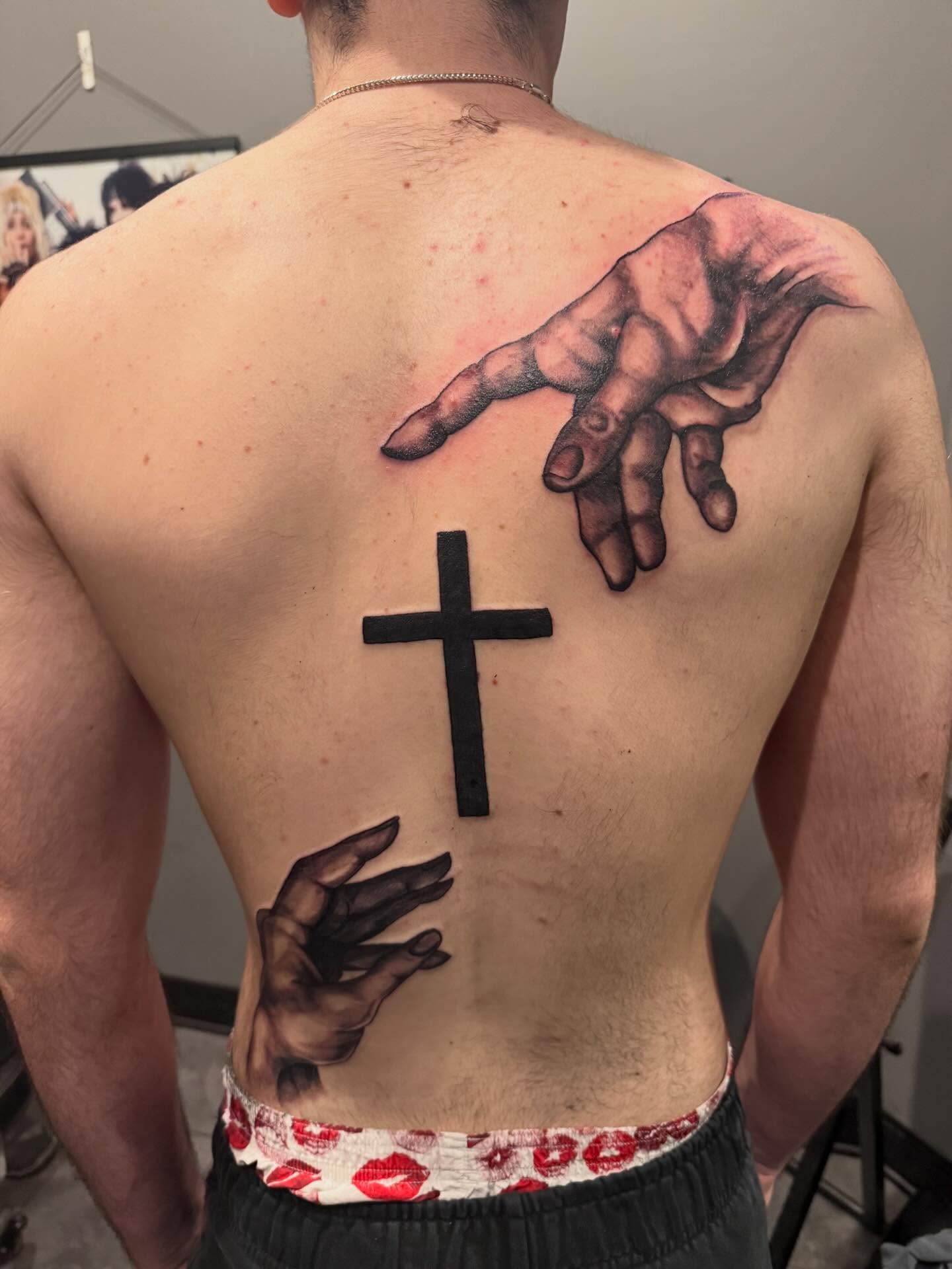 Cross and hands realism tattoo on the back by Courtney