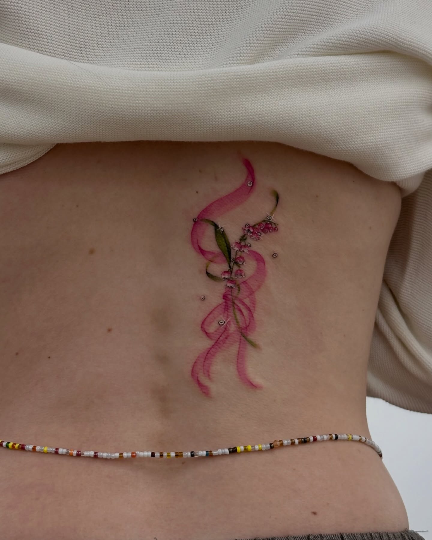 Ribbons and flowers watercolor tattoo on the ribs by Soohee Jin✨ NYC tattoo artist