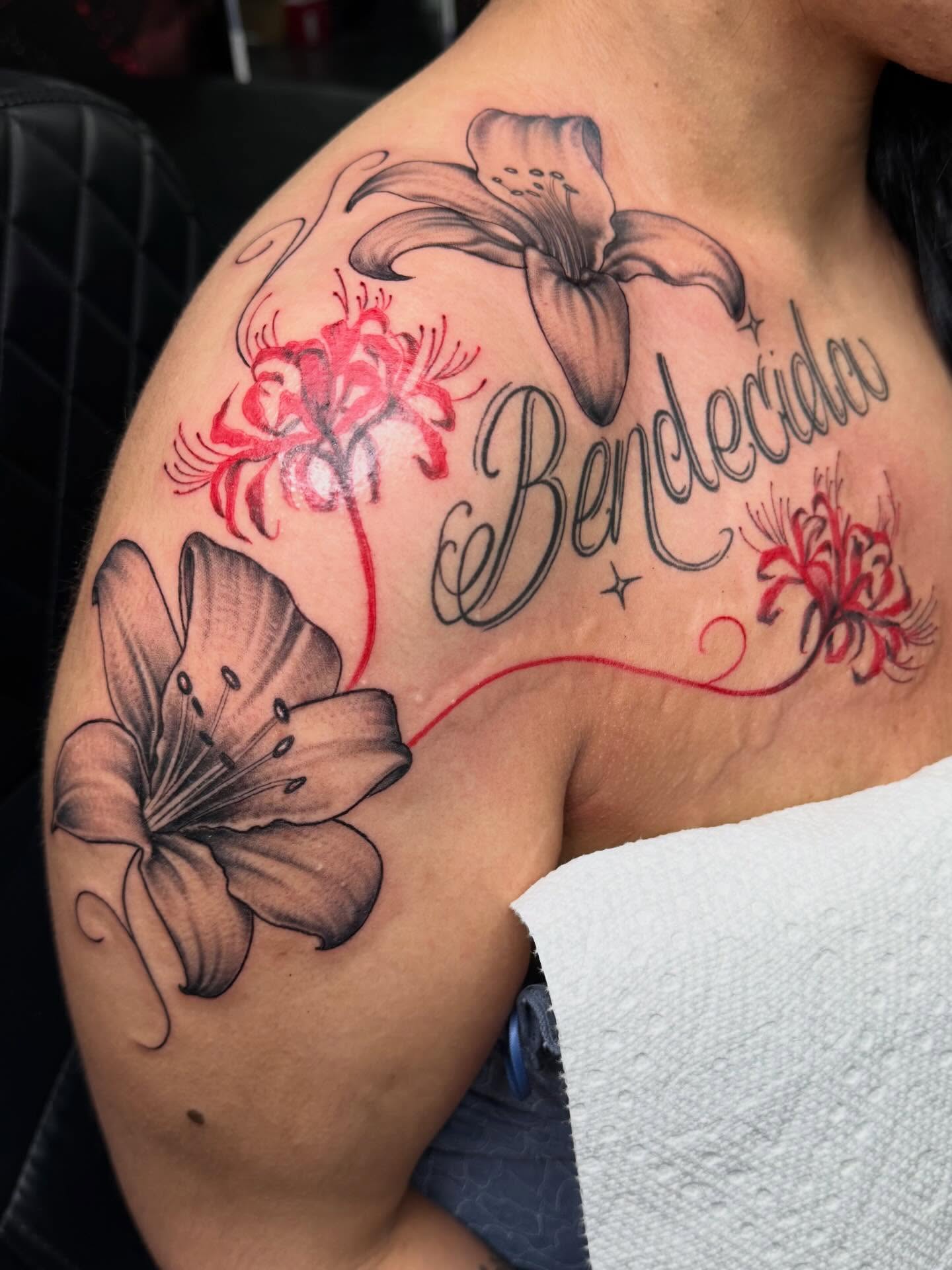Lilies and script black and grey tattoo on the shoulder by Kimberly landin