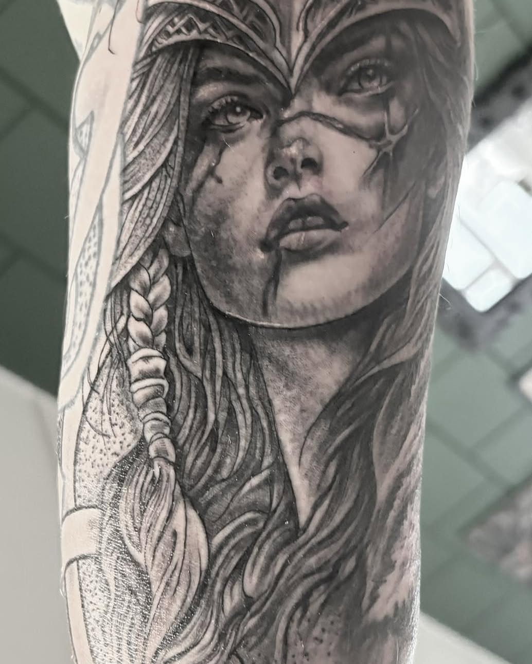 Woman with braided hair realism tattoo on the forearm by Léon Huiting