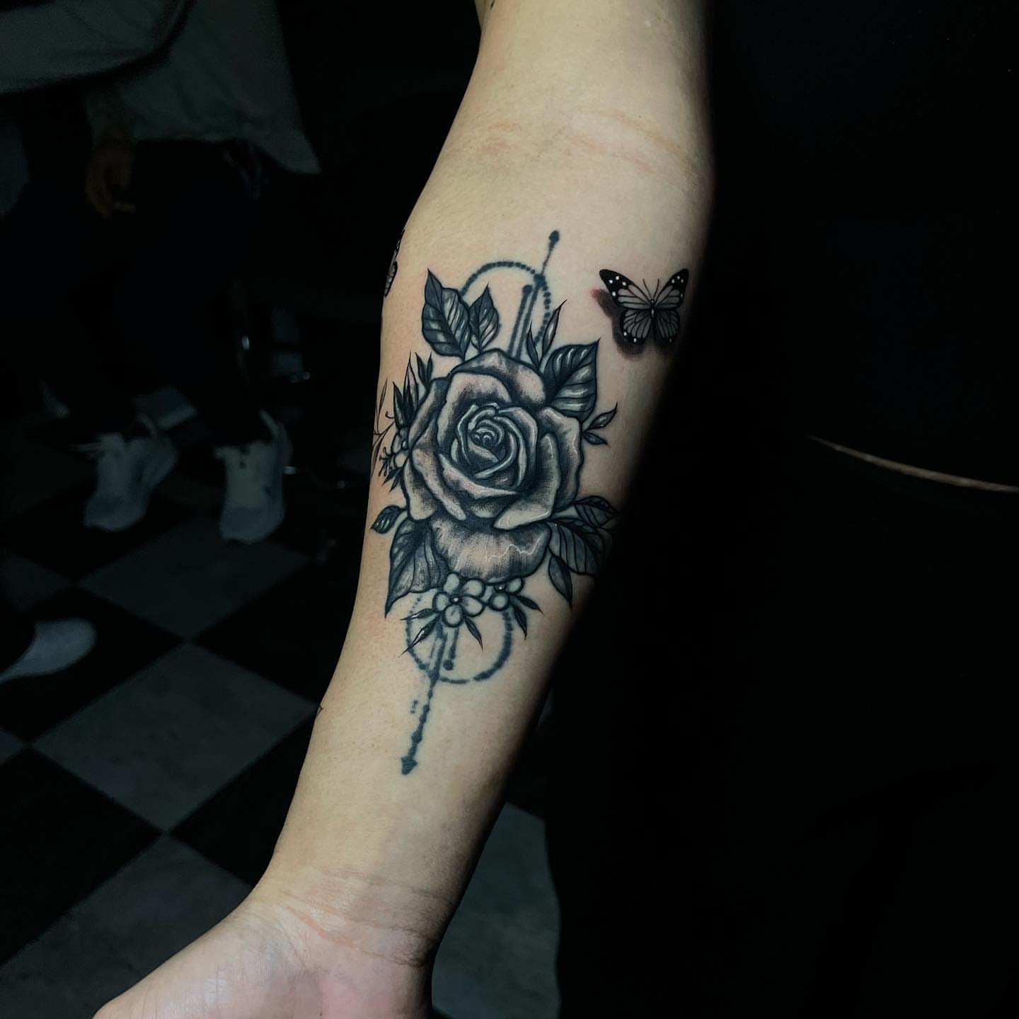 Rose and butterfly black and grey tattoo on the forearm by Nikko