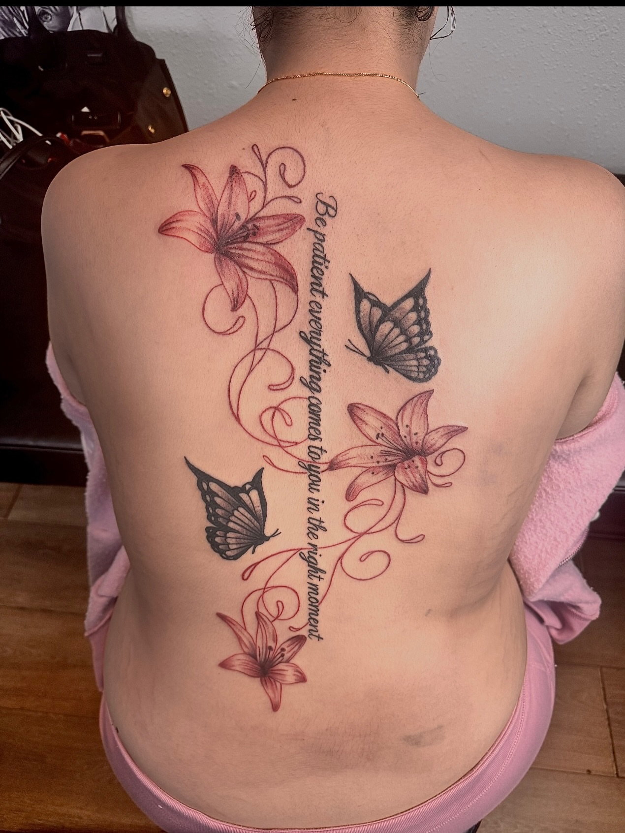 Lilies and butterflies fine line tattoo on the back by Tampa tattoo artist