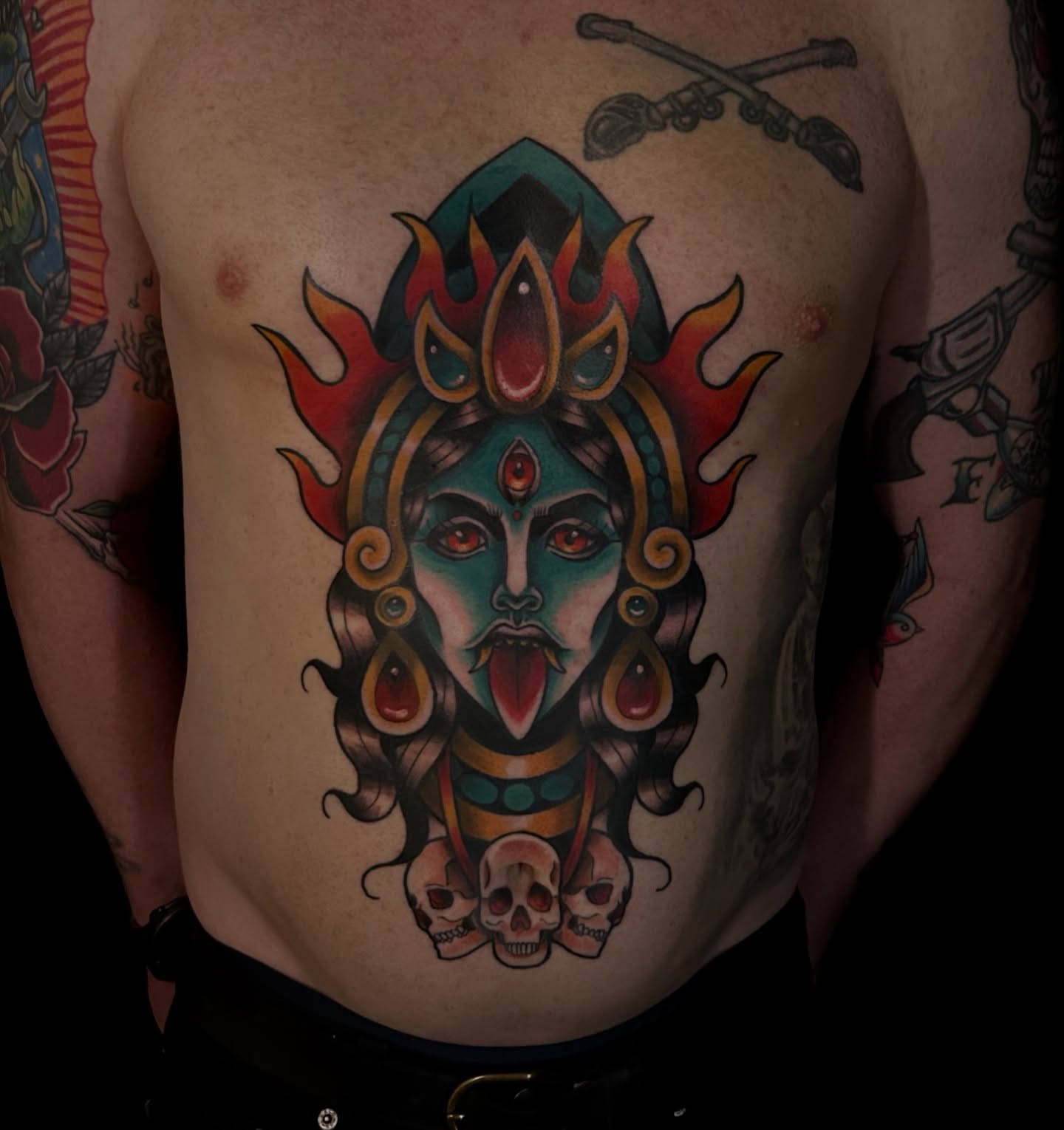 Deity with skulls American traditional tattoo on the chest by Kim Goff - Special K