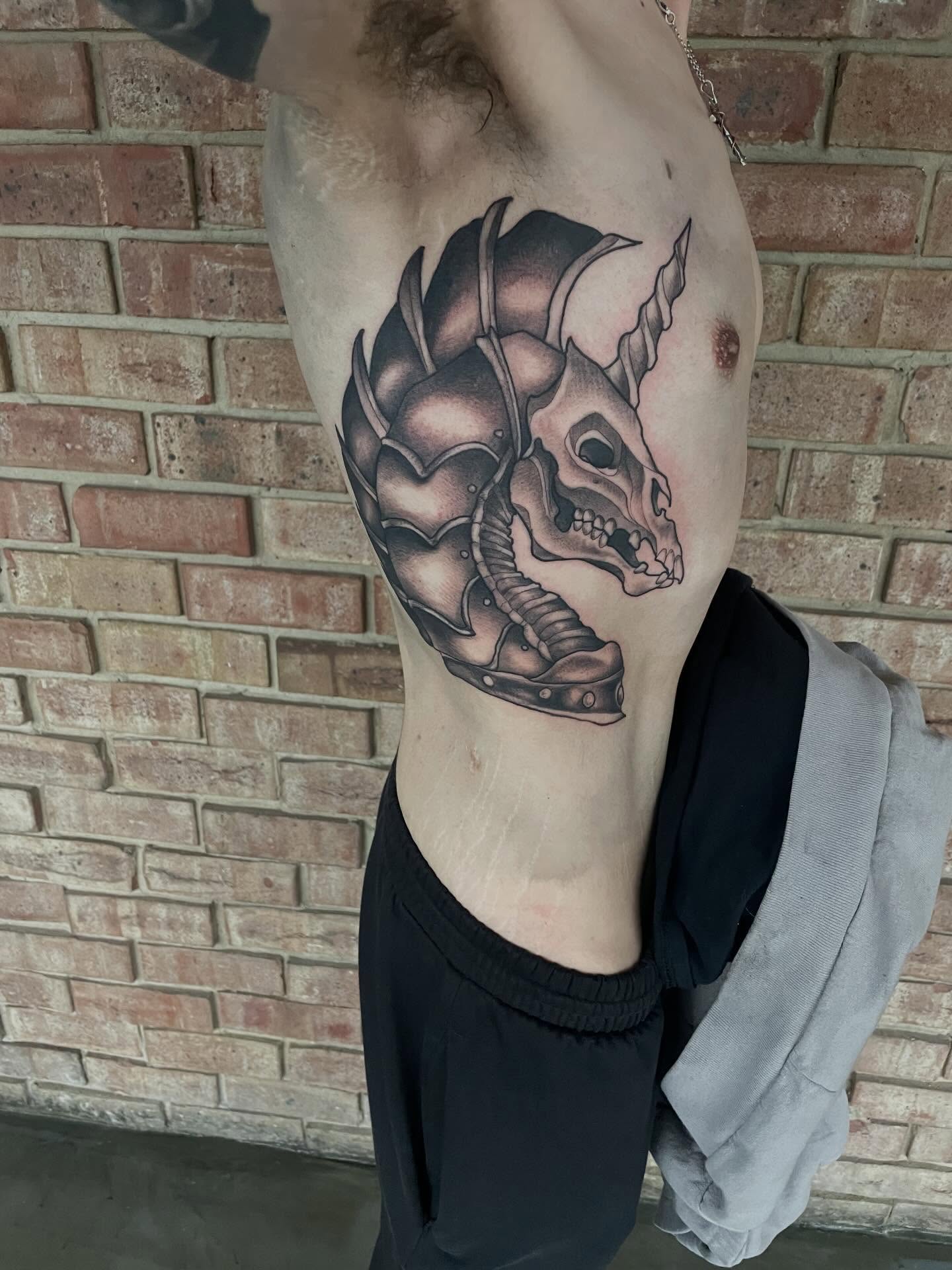 Skull with armor realism tattoo on the ribs by Nathan Evans