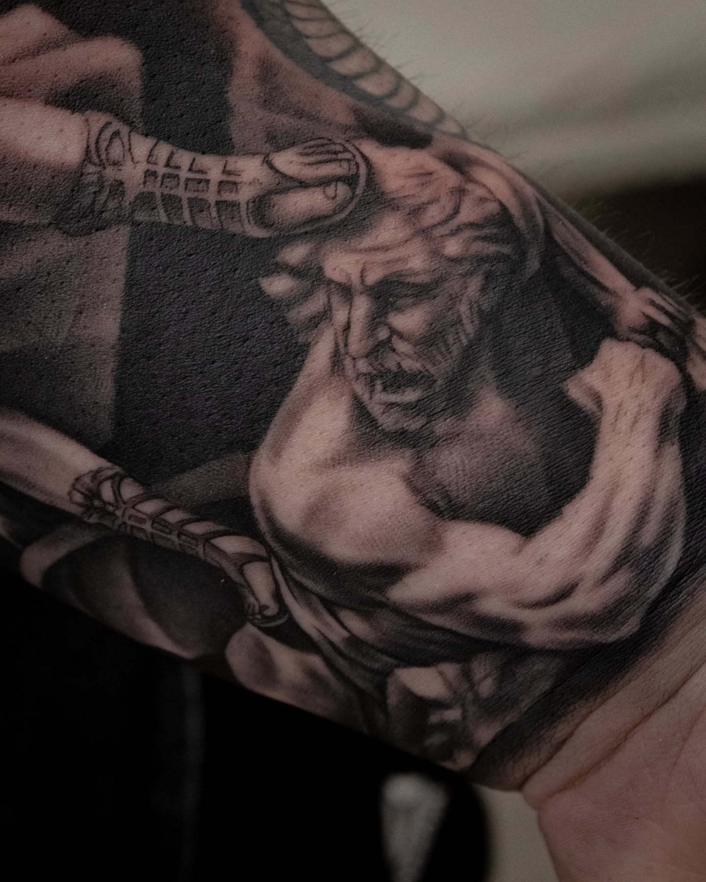 Muscular man realism tattoo on the forearm by Erik Bonilla
