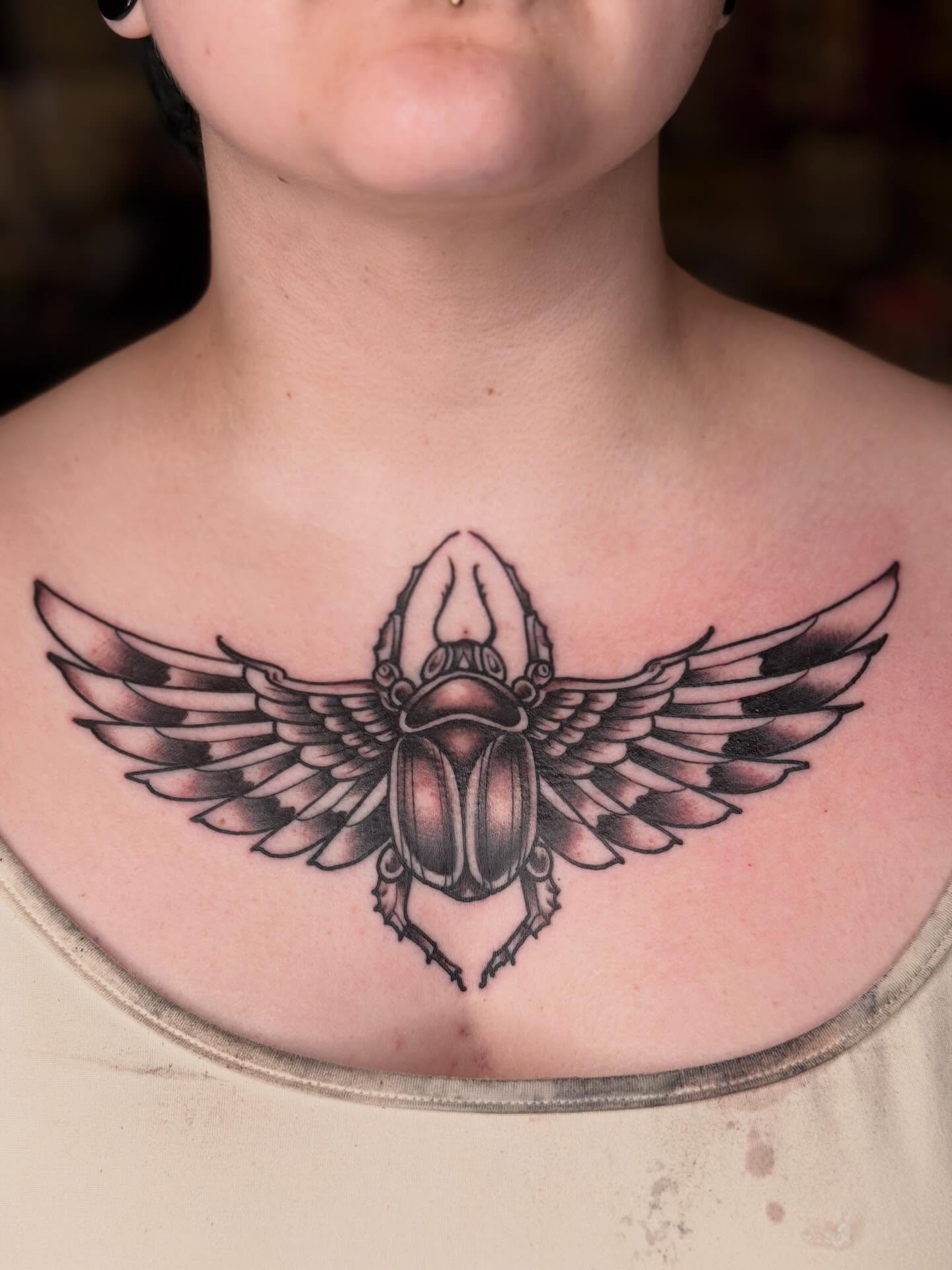 Scarab beetle black and grey tattoo on the chest by Mika Clairissa