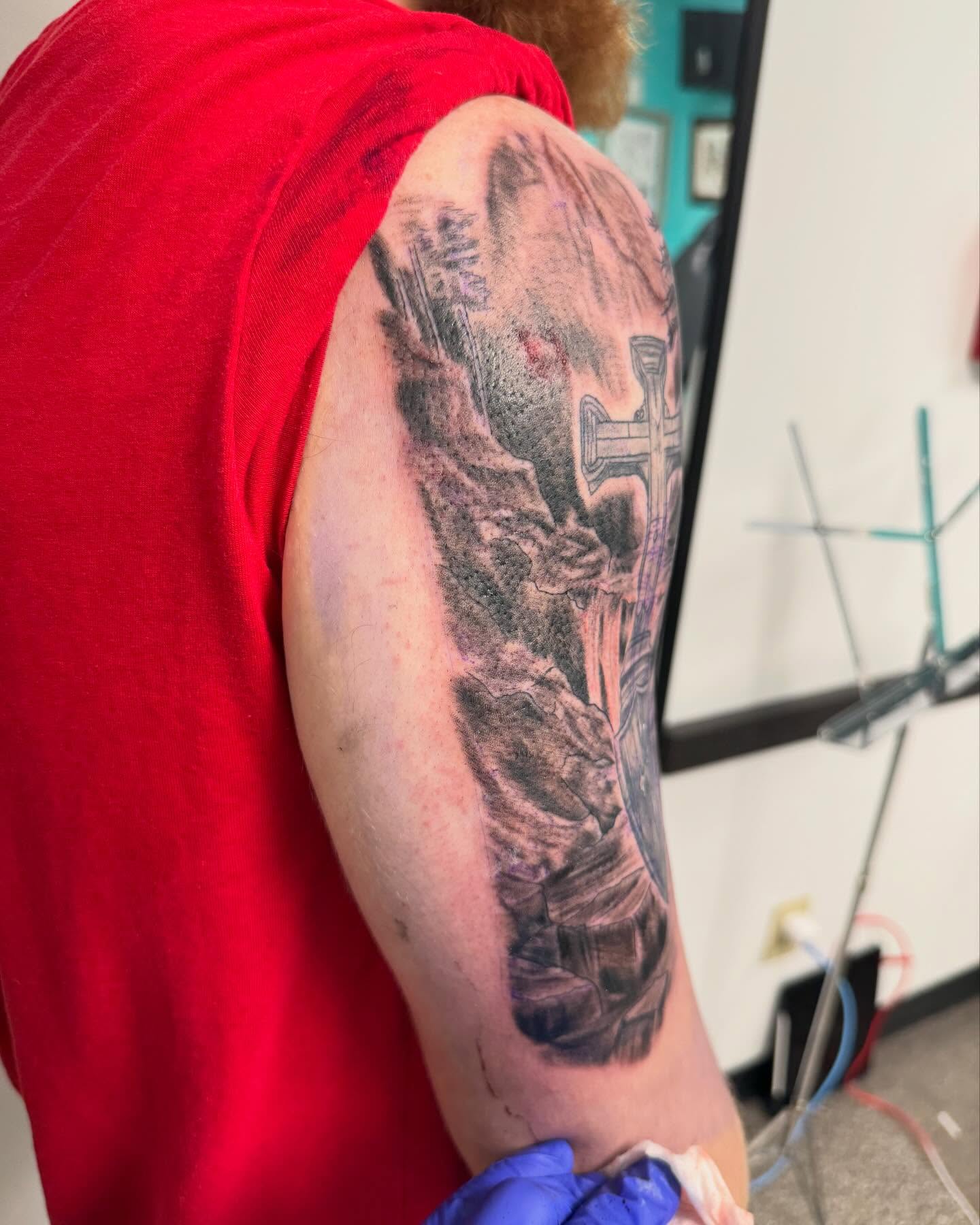 Religious scene realism tattoo on the upper arm by Brazun Locker Poloschan